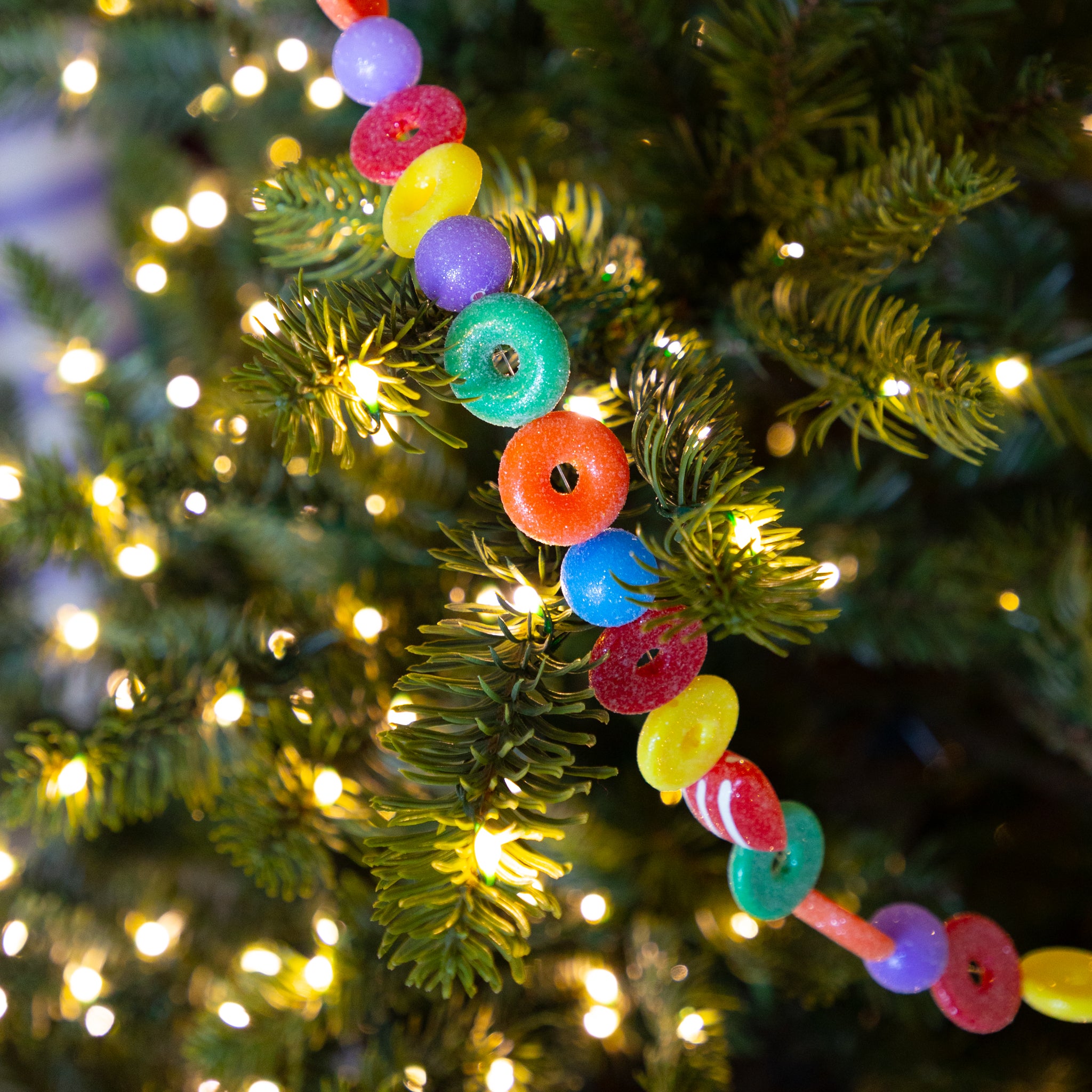 Candy Life-Saver Garland on a Christmas tree with blurred lights in the background.