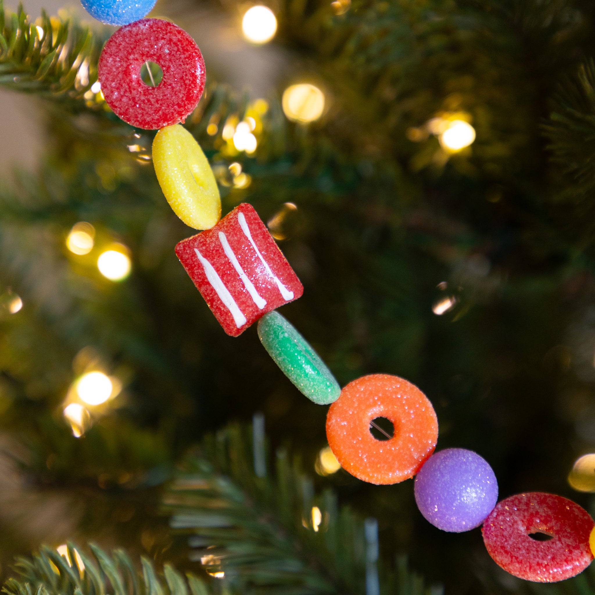 Candy Life-Saver Garland on a Christmas tree with blurred lights in the background.