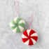 Two felt peppermint candy ornaments in red and seafoam on a marble table.