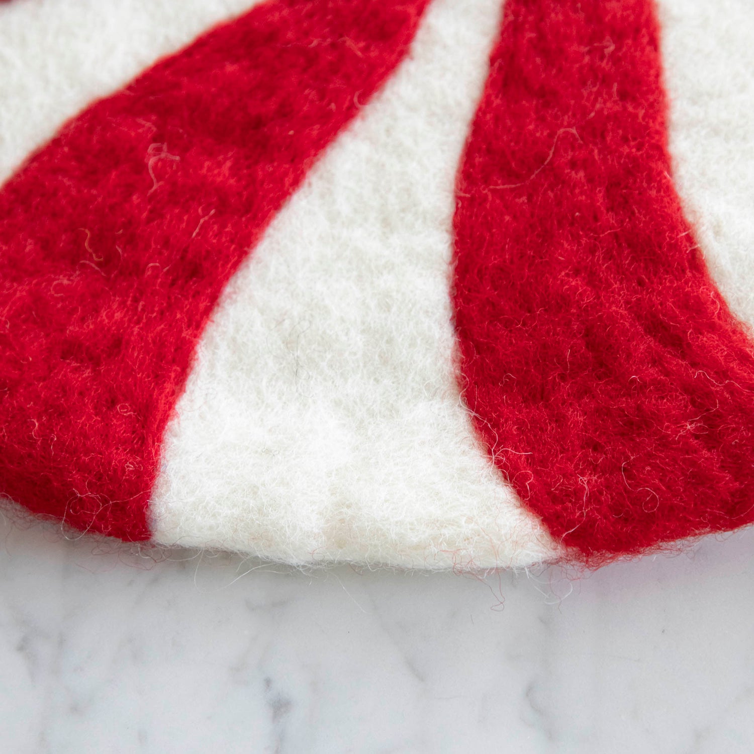 A close up of the Red Felt Candy Stripe Placemat showing the wool.