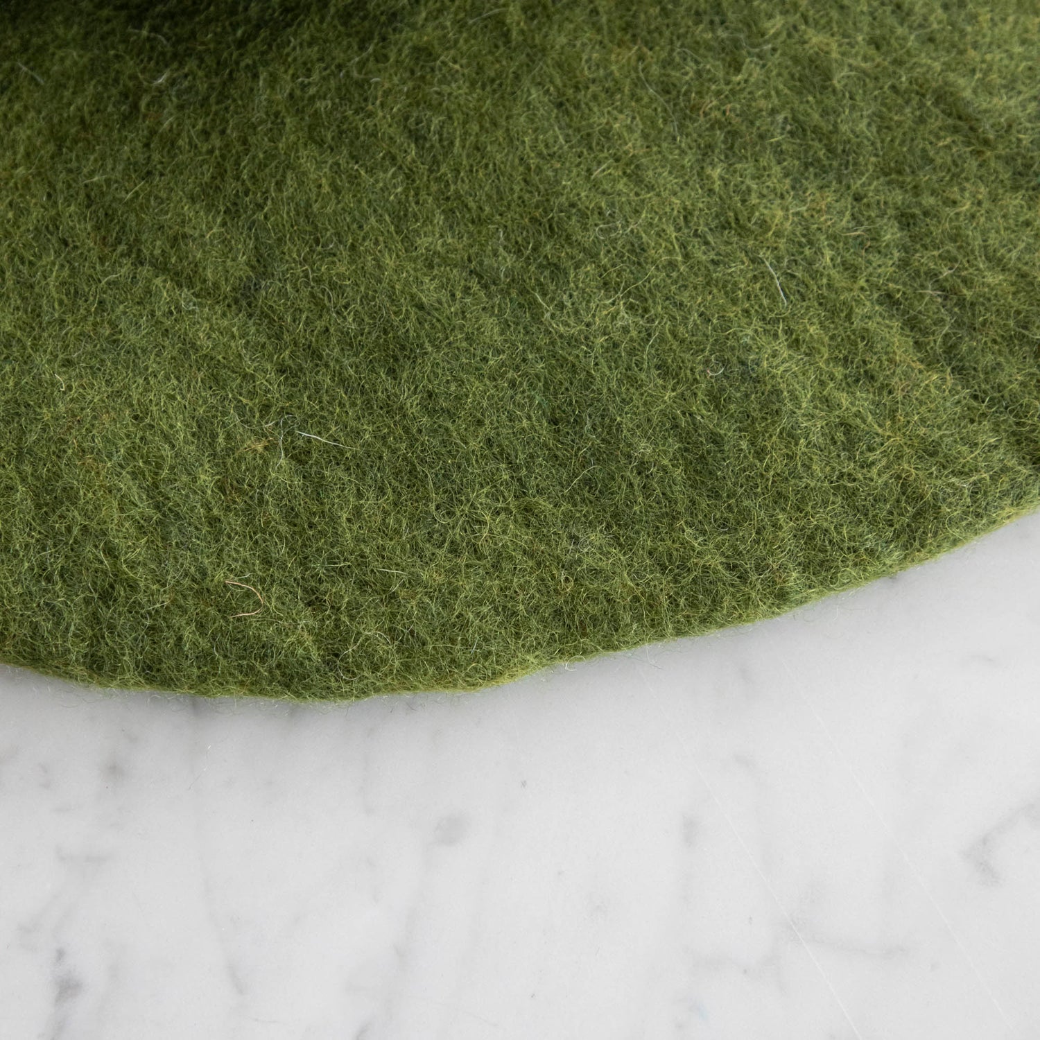 A close up of the Forest Green Felt Placemat showing the wool details.