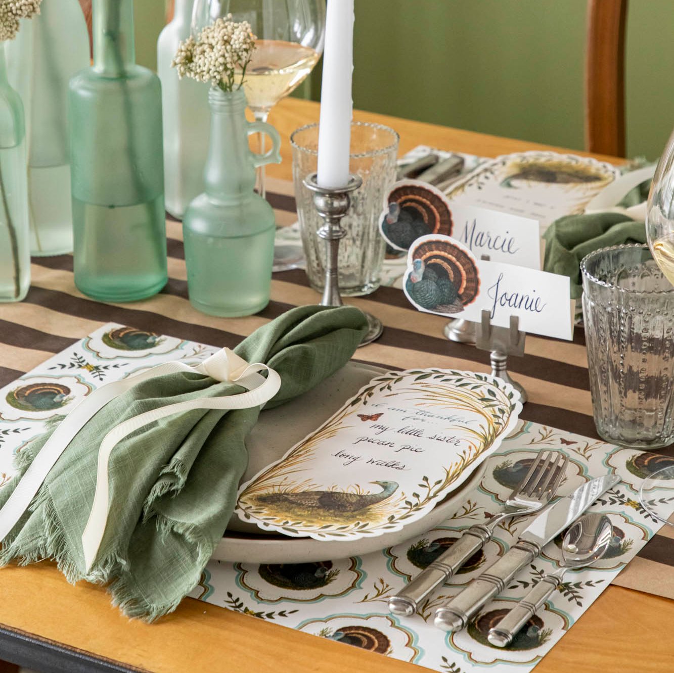 Elegant tablescape with the Heritage Turkey Meadow placemat, dinnerware, a coordinating napkin and bottleneck vases with flowers..