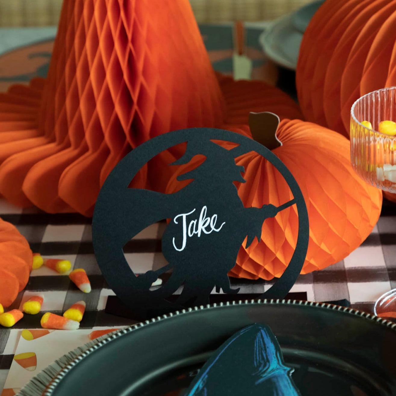 Halloween themed tablescape with a die-cut wicked witch silhouette with the name &quot;Jake&quot; written on it.