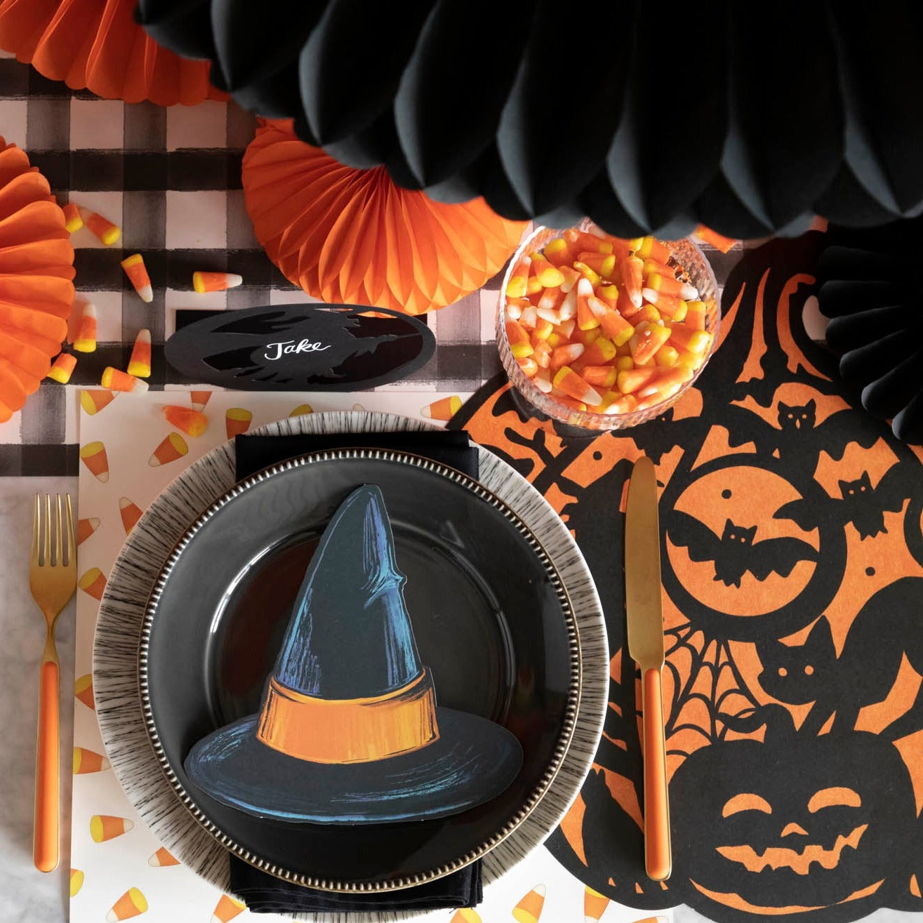 Halloween themed table setting with a die-cut wicked pumpkin placemat and dinnerware.