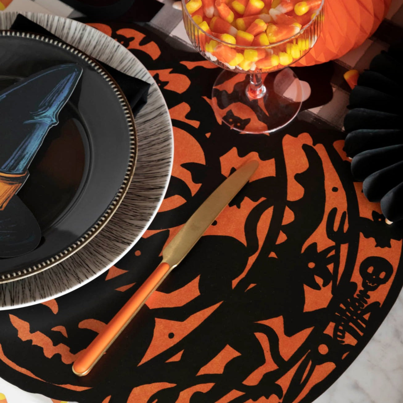 Halloween themed table setting with a die-cut wicked pumpkin placemat and dinnerware.