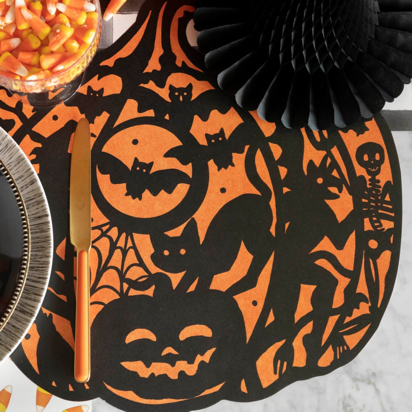 Die-cut Wicked Jack-o-Lantern Placemat with candy corn and halloween decorations.