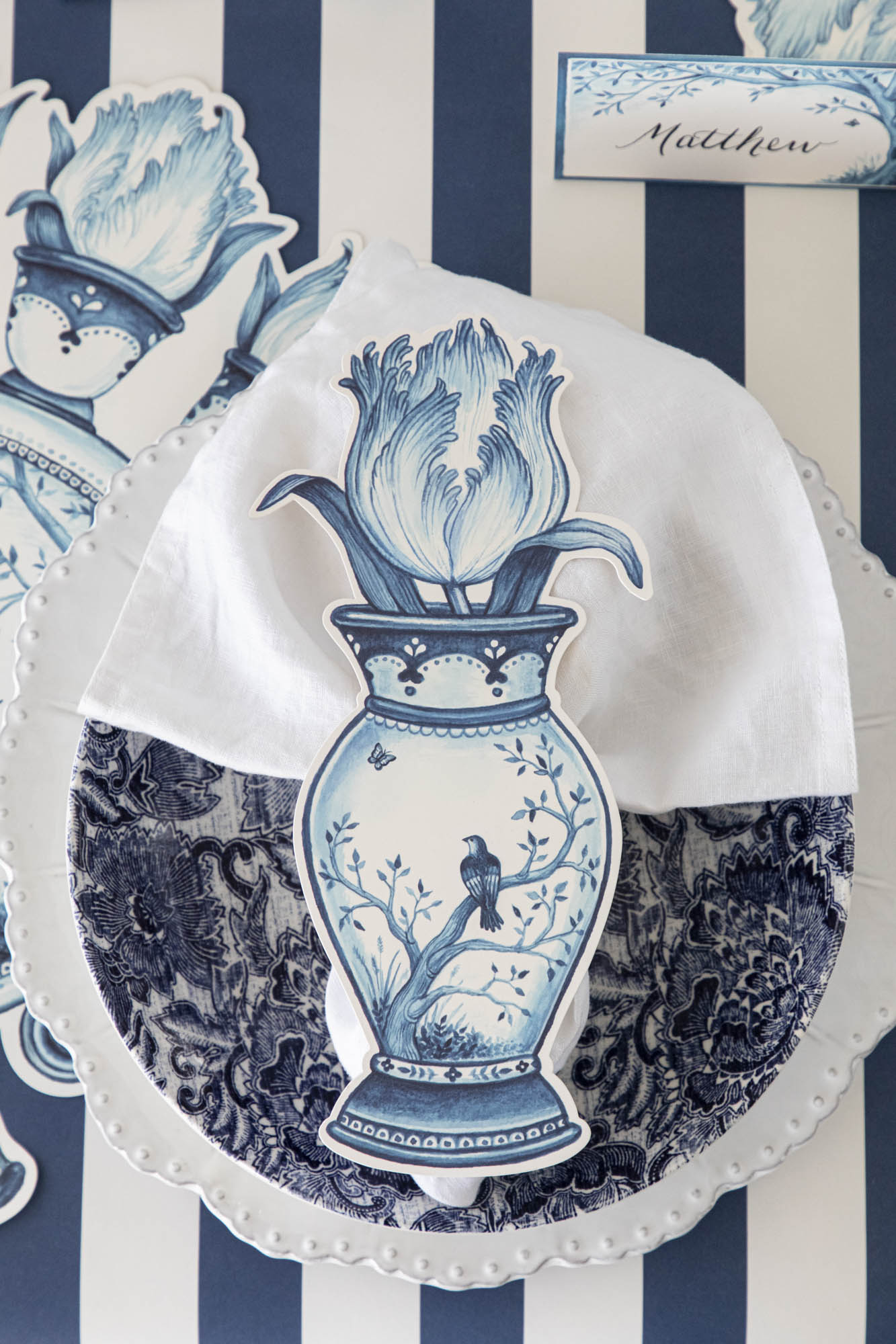 A blue and white table setting with a vase of flowers, creating an Indigo Tulip Table Accent by Hester & Cook.