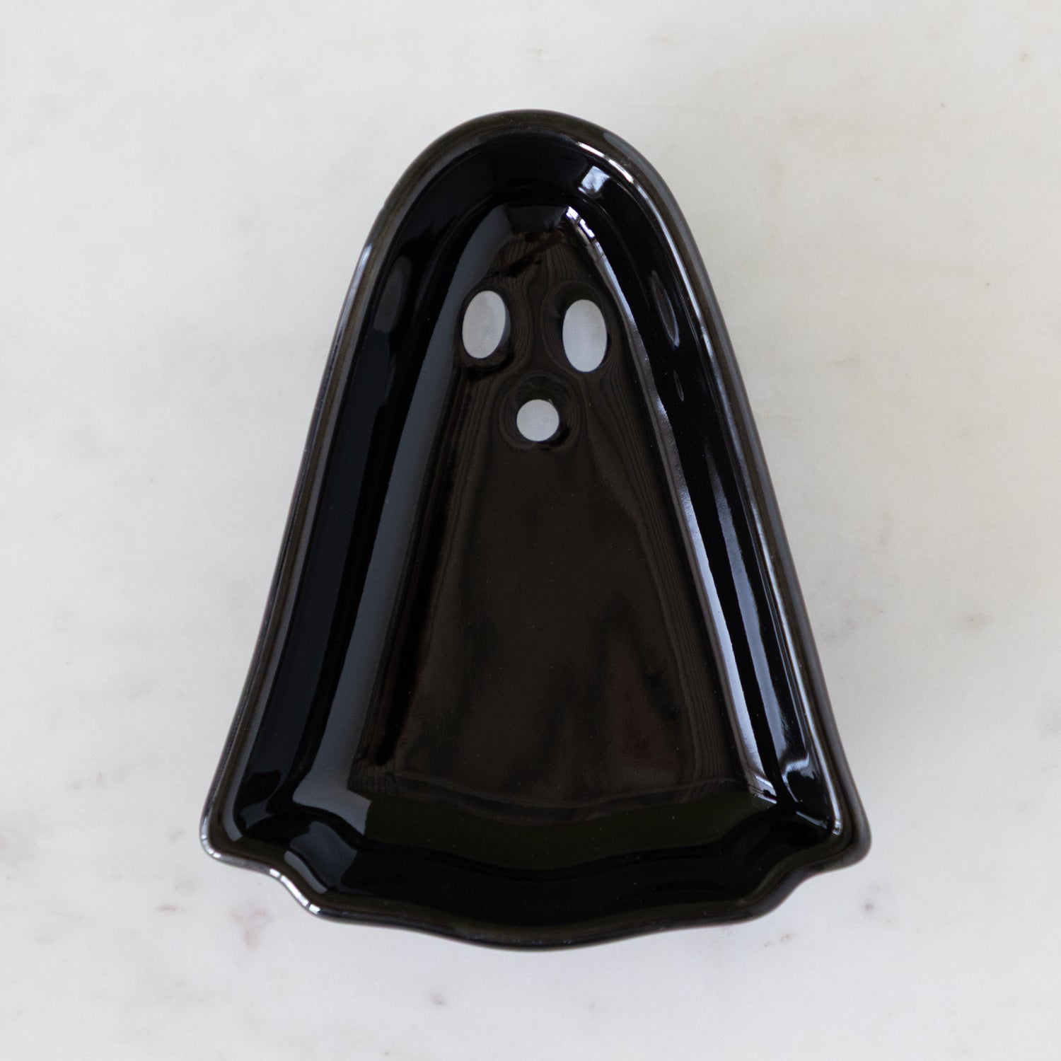 Ghost Pinch Bowl in black on a marbled table.