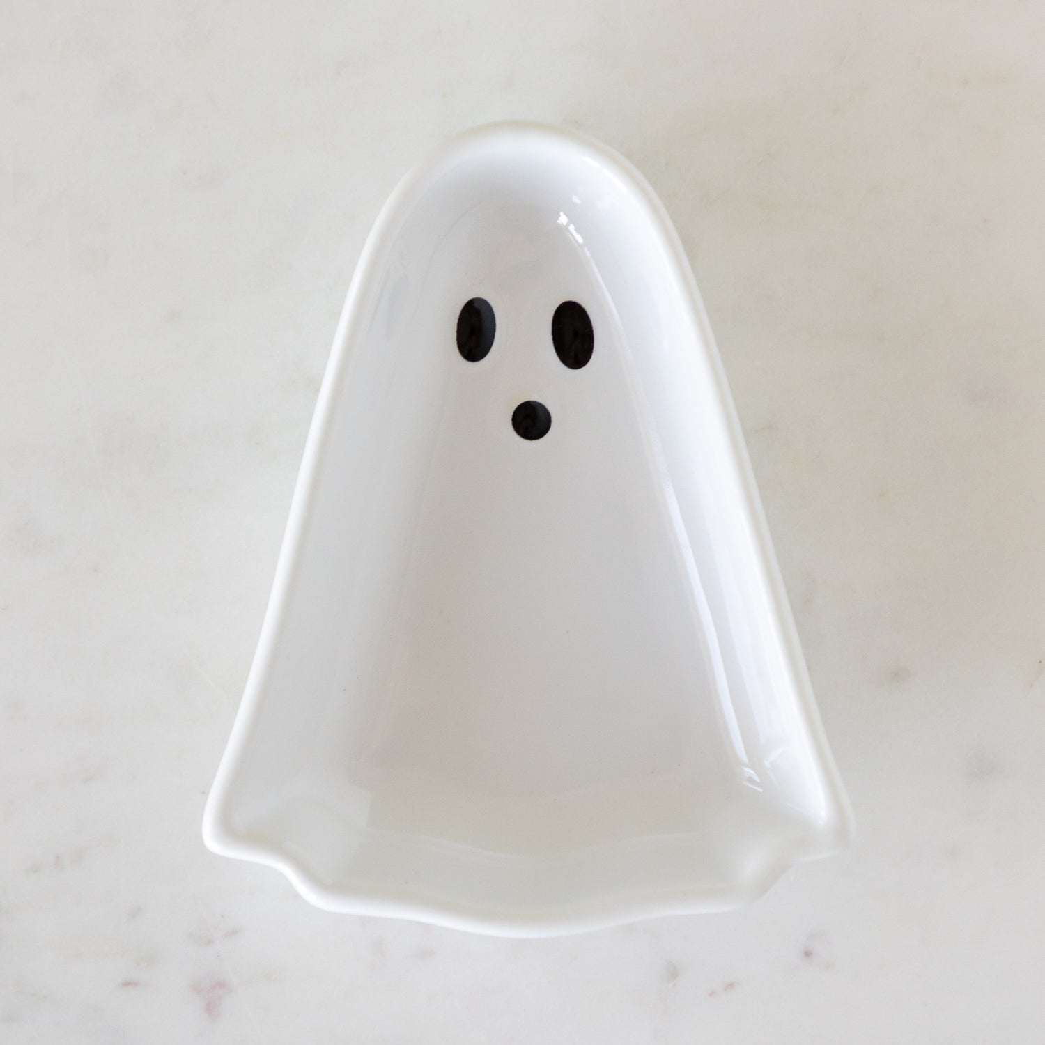 Ghost Pinch Bowl in white on a marbled table.