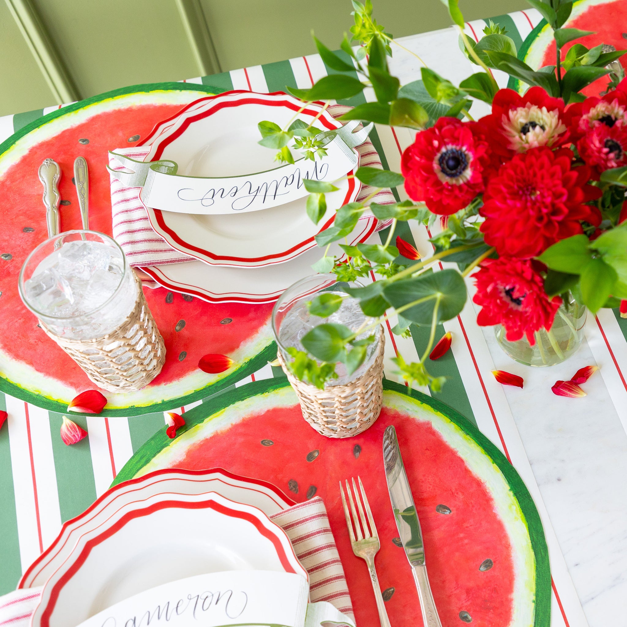 Table setting with Die-cut Watermelon Placemat, glasses, and cutlery on the Green & Red Awning Stripe Runner.