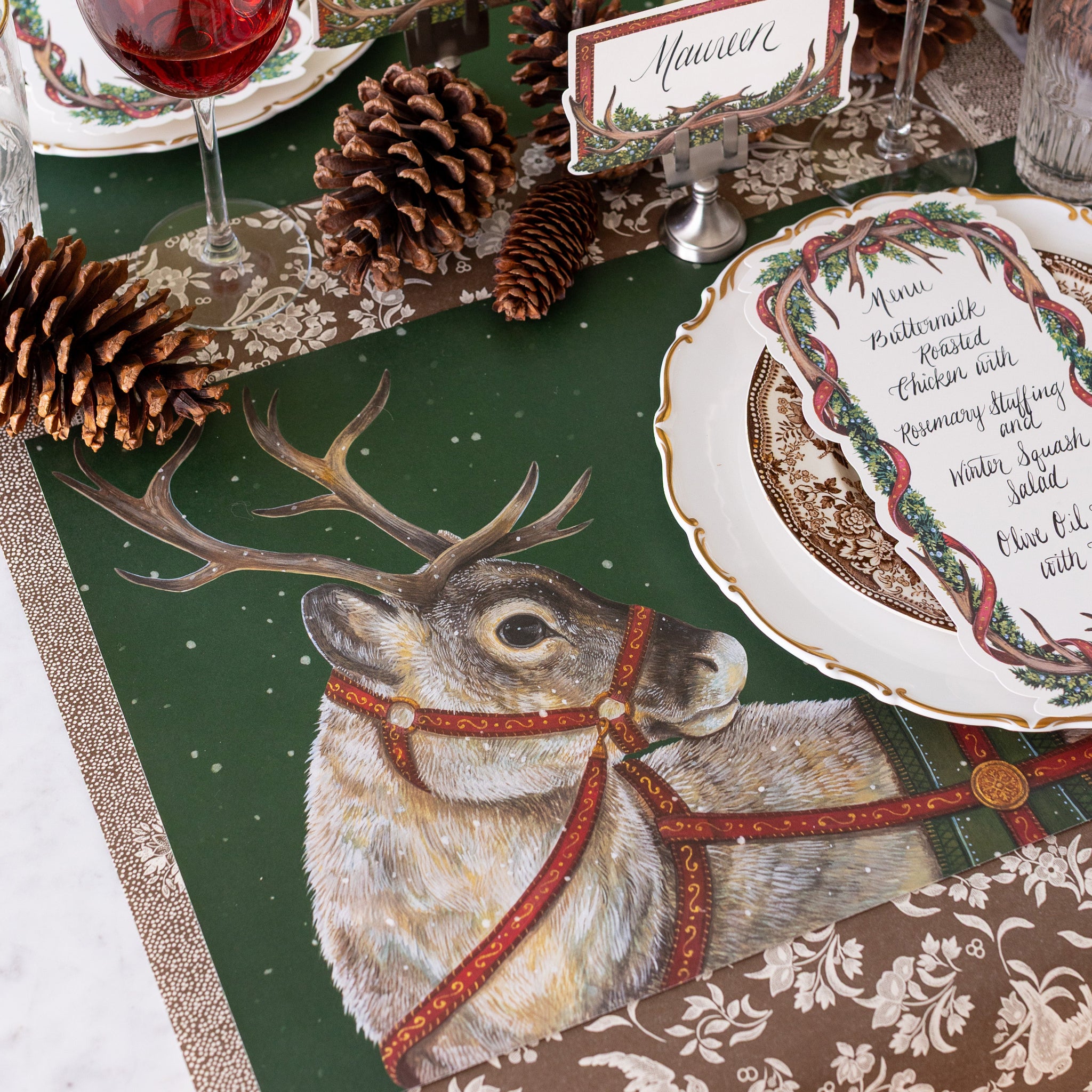 Decorative table setting with the Holiday Reindeer Placemat, Antler Garland Table Card, and Antler Frame Place Cards on the Brown Regal Peacock Runner.