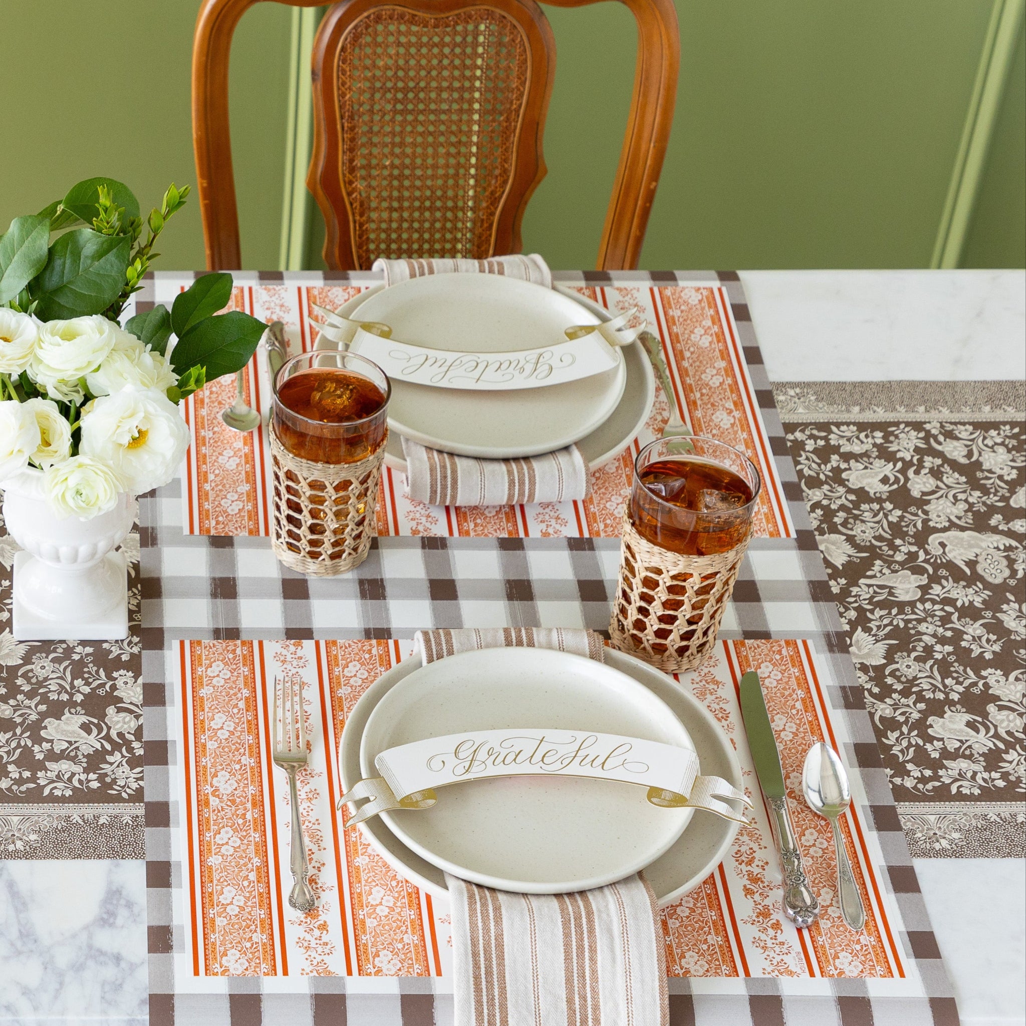 The Brown Regal Peacock Runner under a table setting with the Pumpkin Burleigh Stripe Placemat, Grateful Banner Table Accents, Brown Painted Check Runner, vintage silverware, and glasses of iced tea.