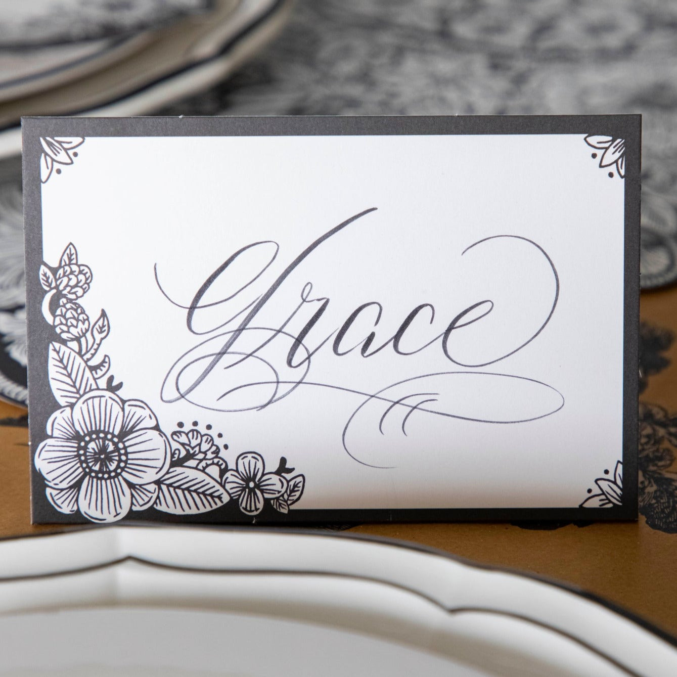 Close-up of an Ebony Harvest Blooms Place Card labeled &quot;Grace&quot; in elegant script.