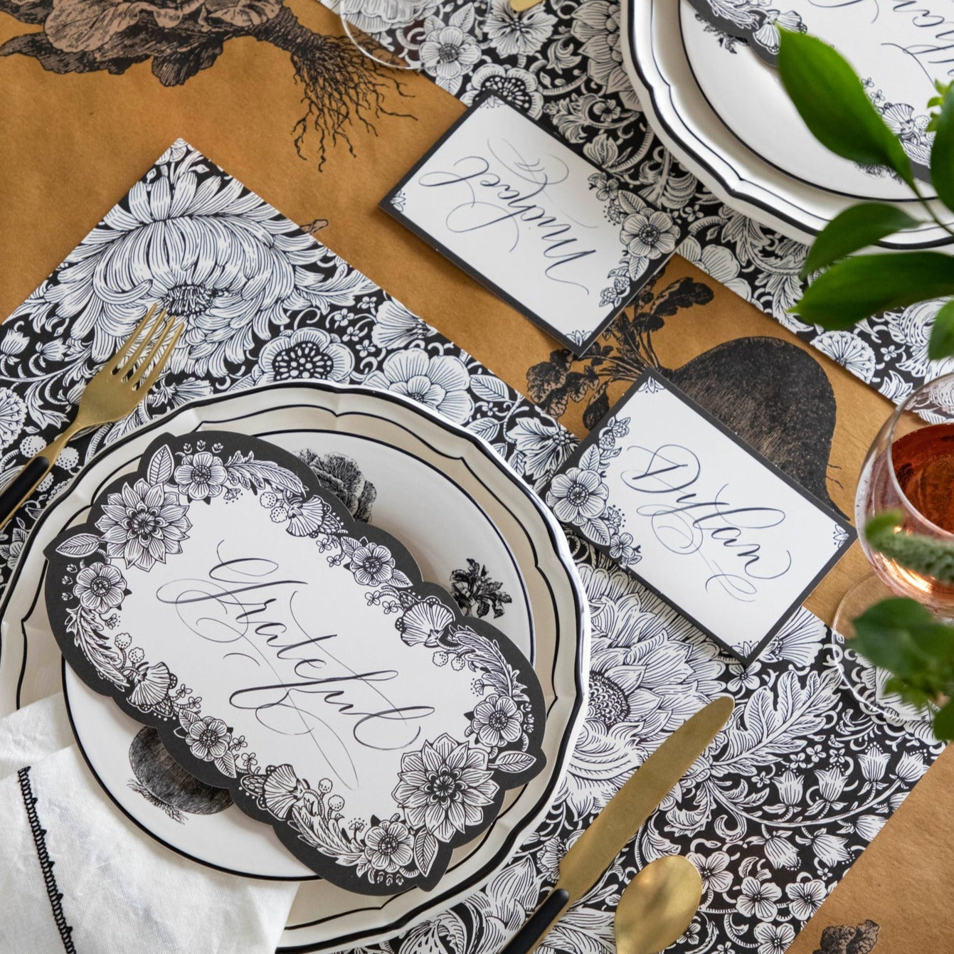 An elegant place setting featuring an Ebony Harvest Blooms Table Card with &quot;Thankful&quot; written on it in lovely script resting on the plate.