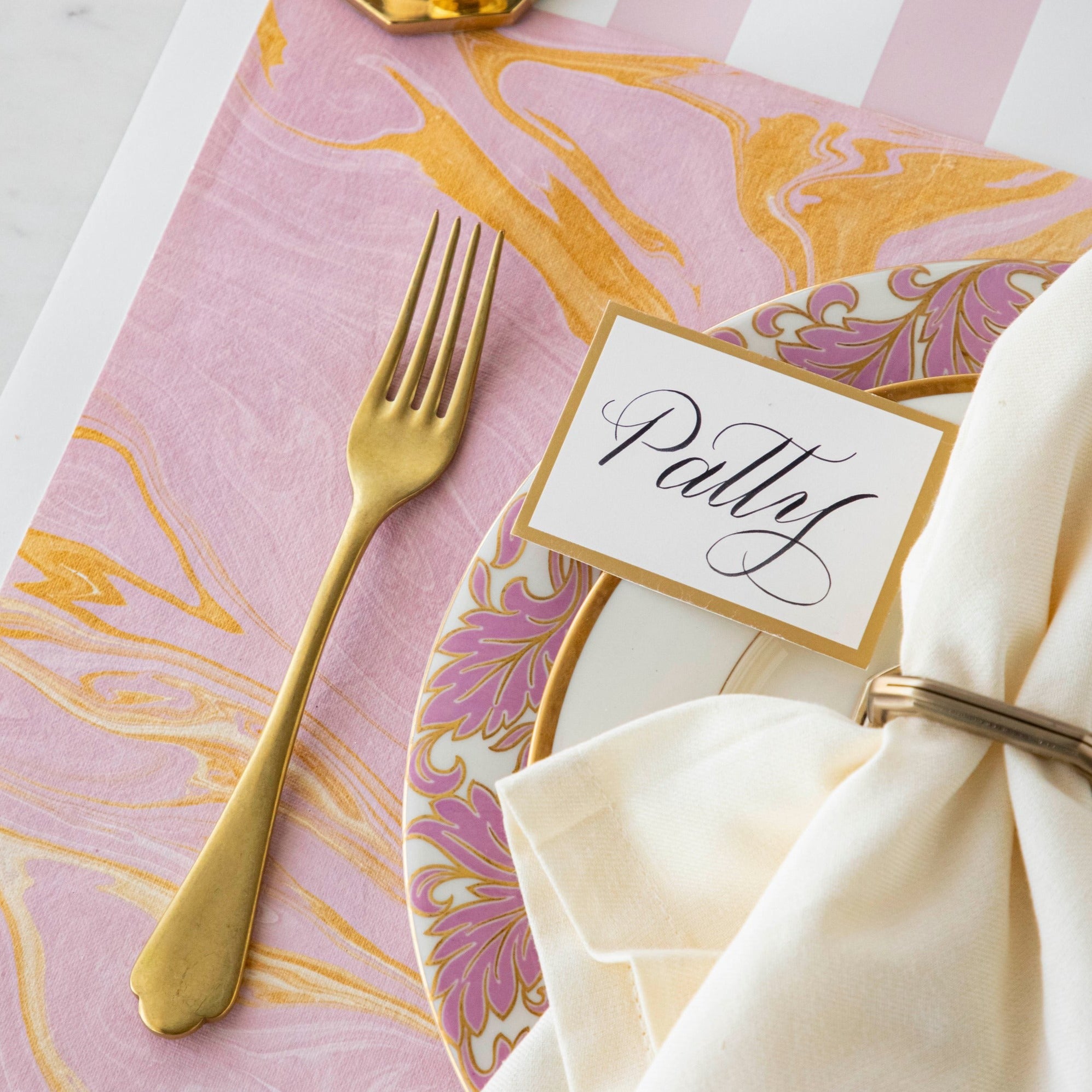 Close-up of the Pink & Gold Vein Marbled Placemat under an elegant place setting.