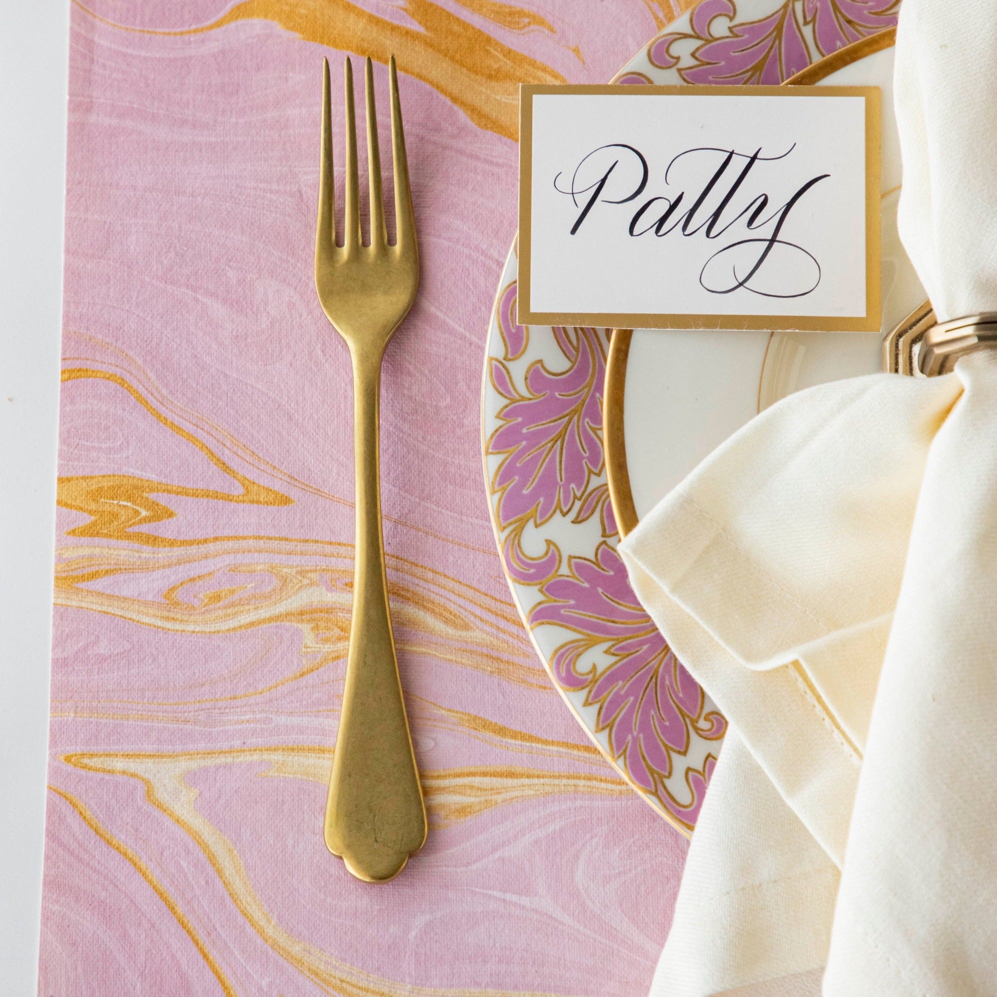 Close-up of the Pink & Gold Vein Marbled Placemat under an elegant place setting, showing the gold and pink colors swirled together.