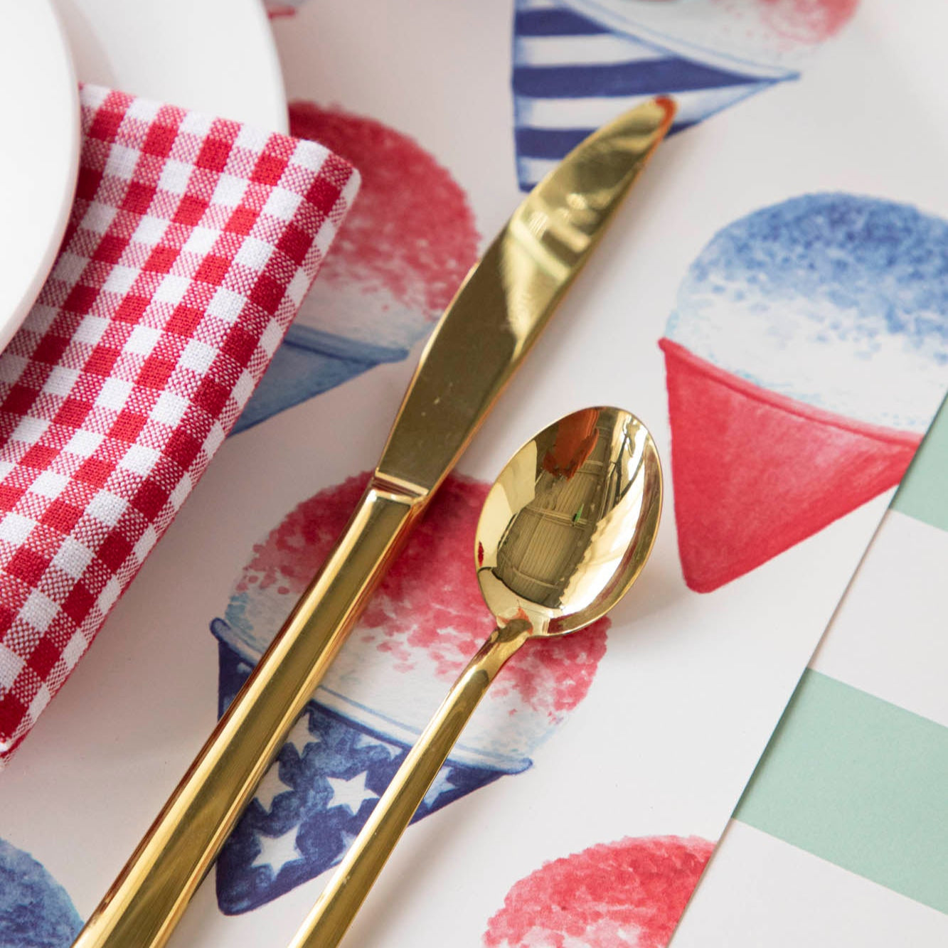 Close-up of a Snow Cone Placemat under gold flatware, showing the artwork in detail.