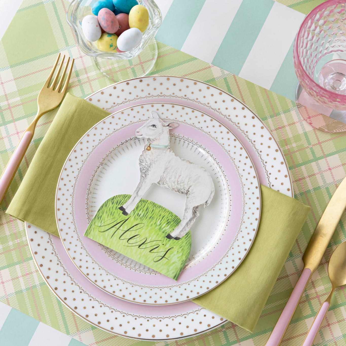 Welcome Little Lamb Place Card with "Alexis" written on it, centered on dinner plates on a place setting for one.