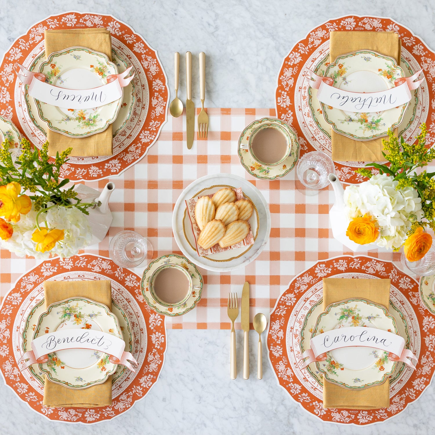 A fall table setting with floral centerpieces and Madeline&