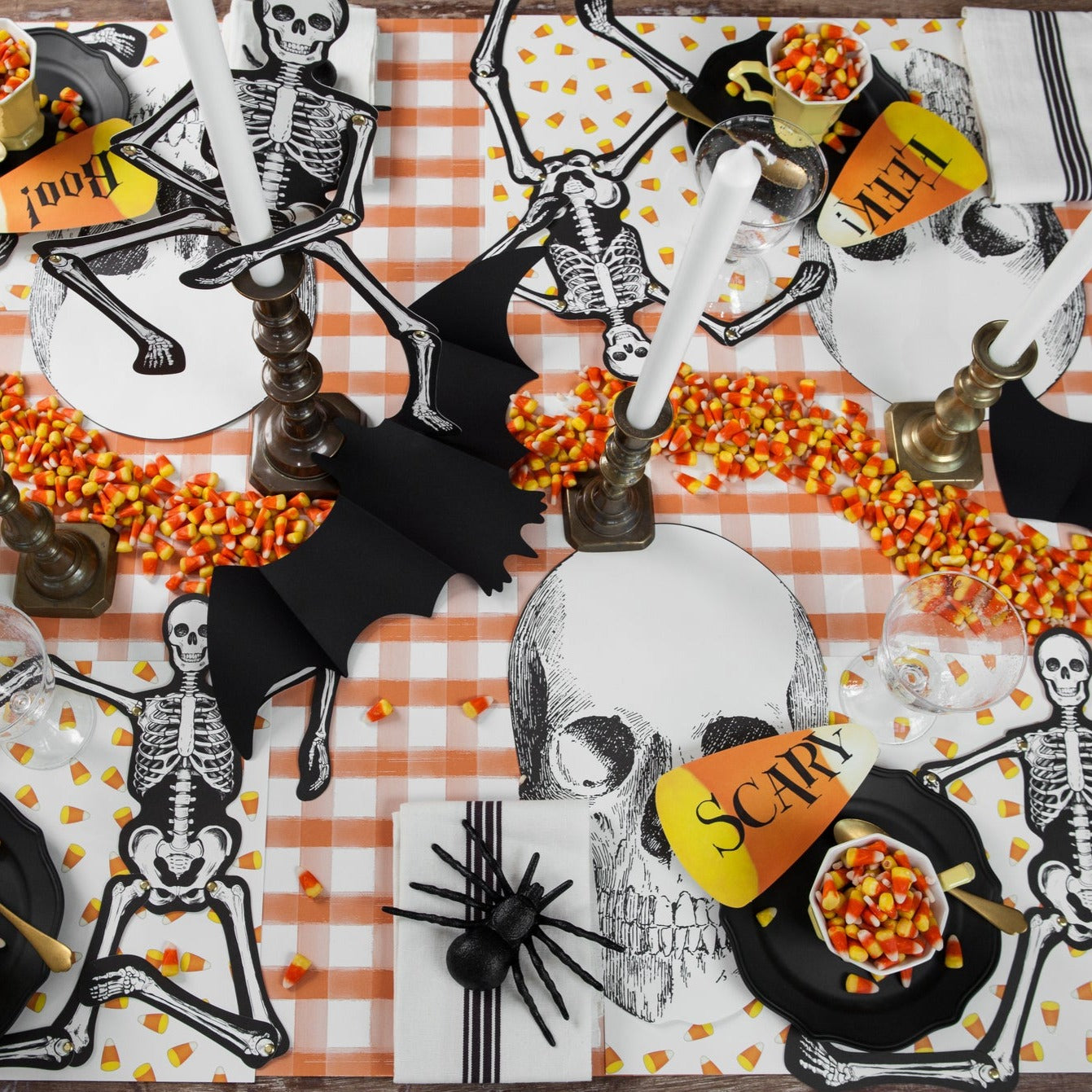 Halloween themed tablescape with various bats, skulls, skeletons and spider paper dinnerware.