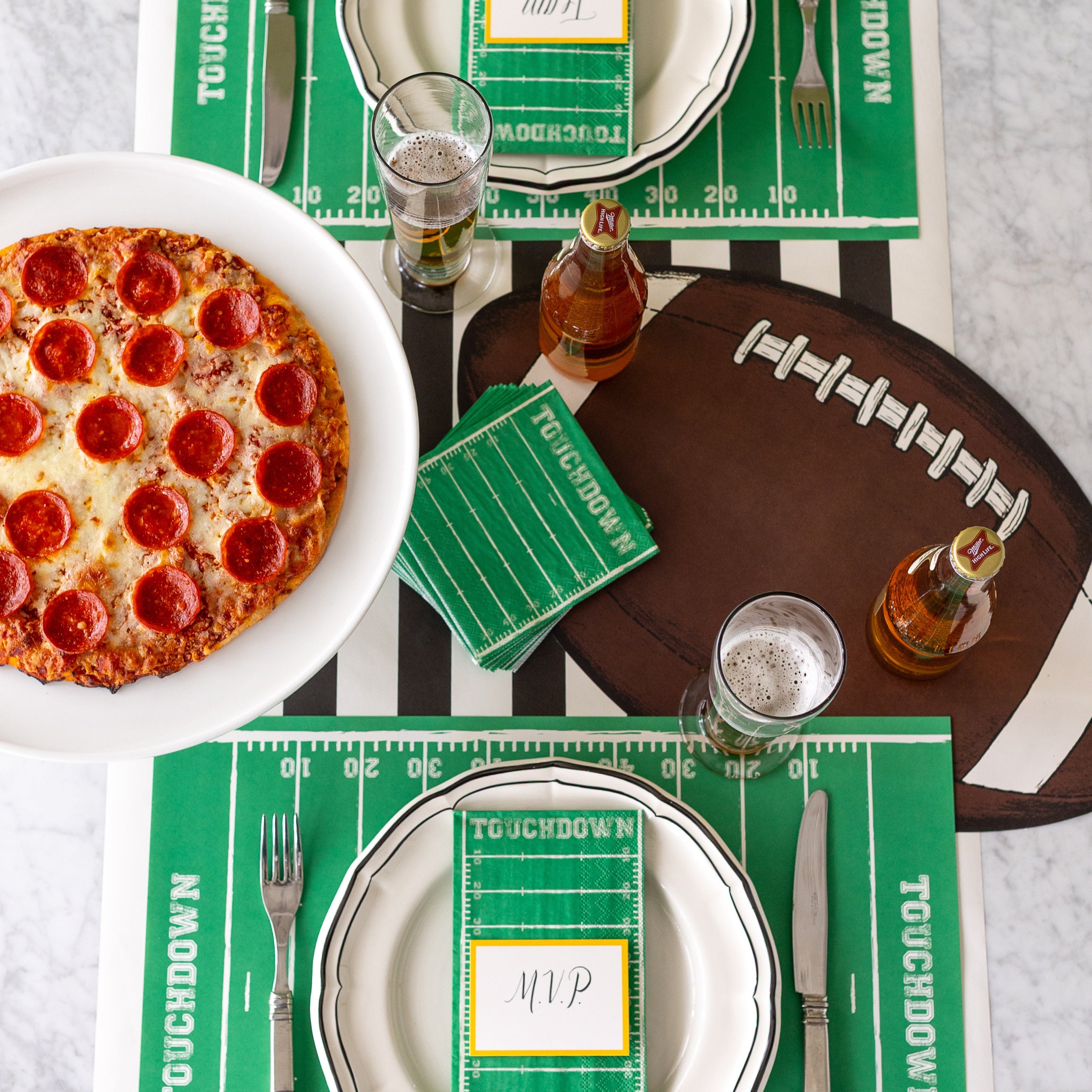 A football themed table setting with the Touchdown Cocktail Napkins in the center.