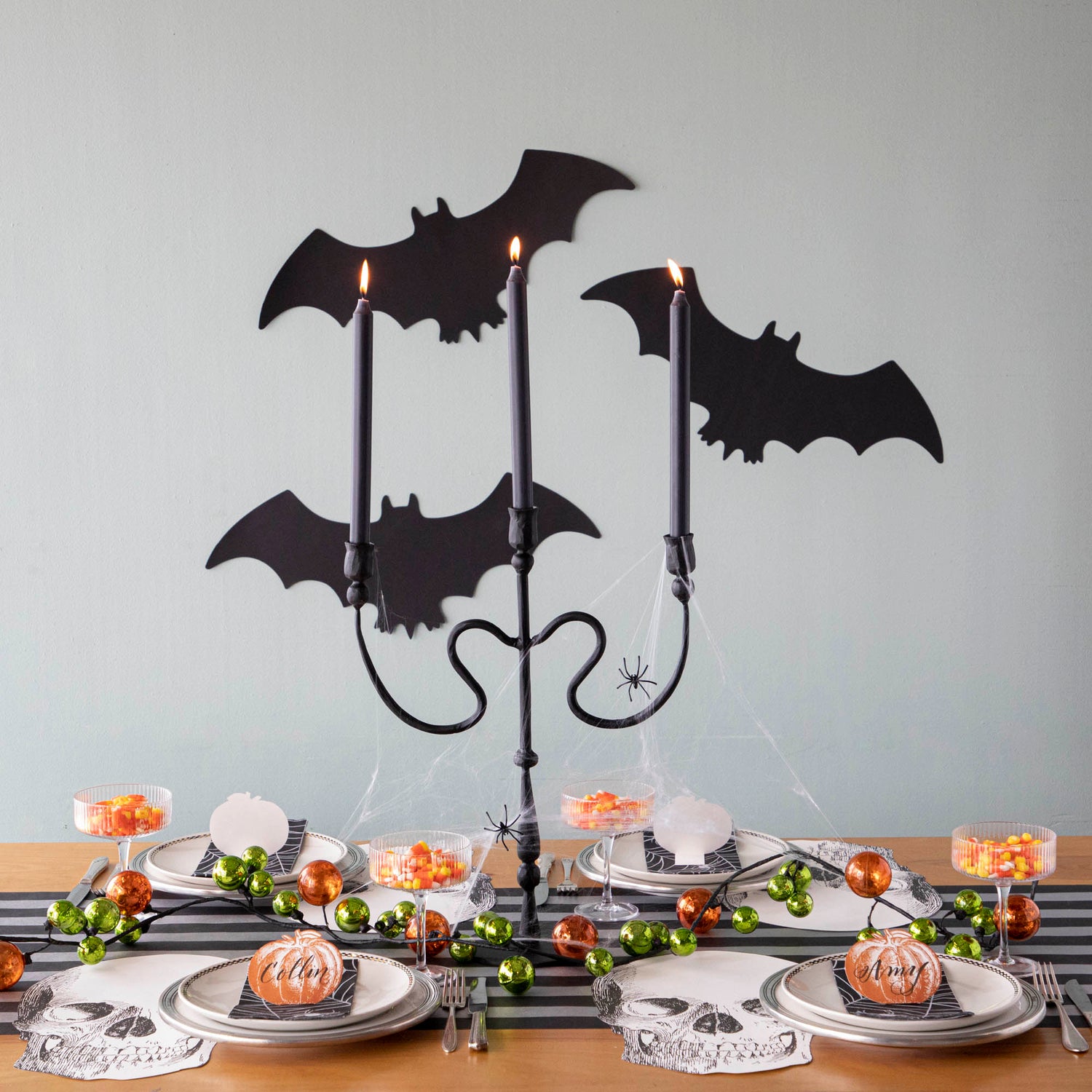 Halloween themed tablescape with die-cut silhouette bats on the wall.