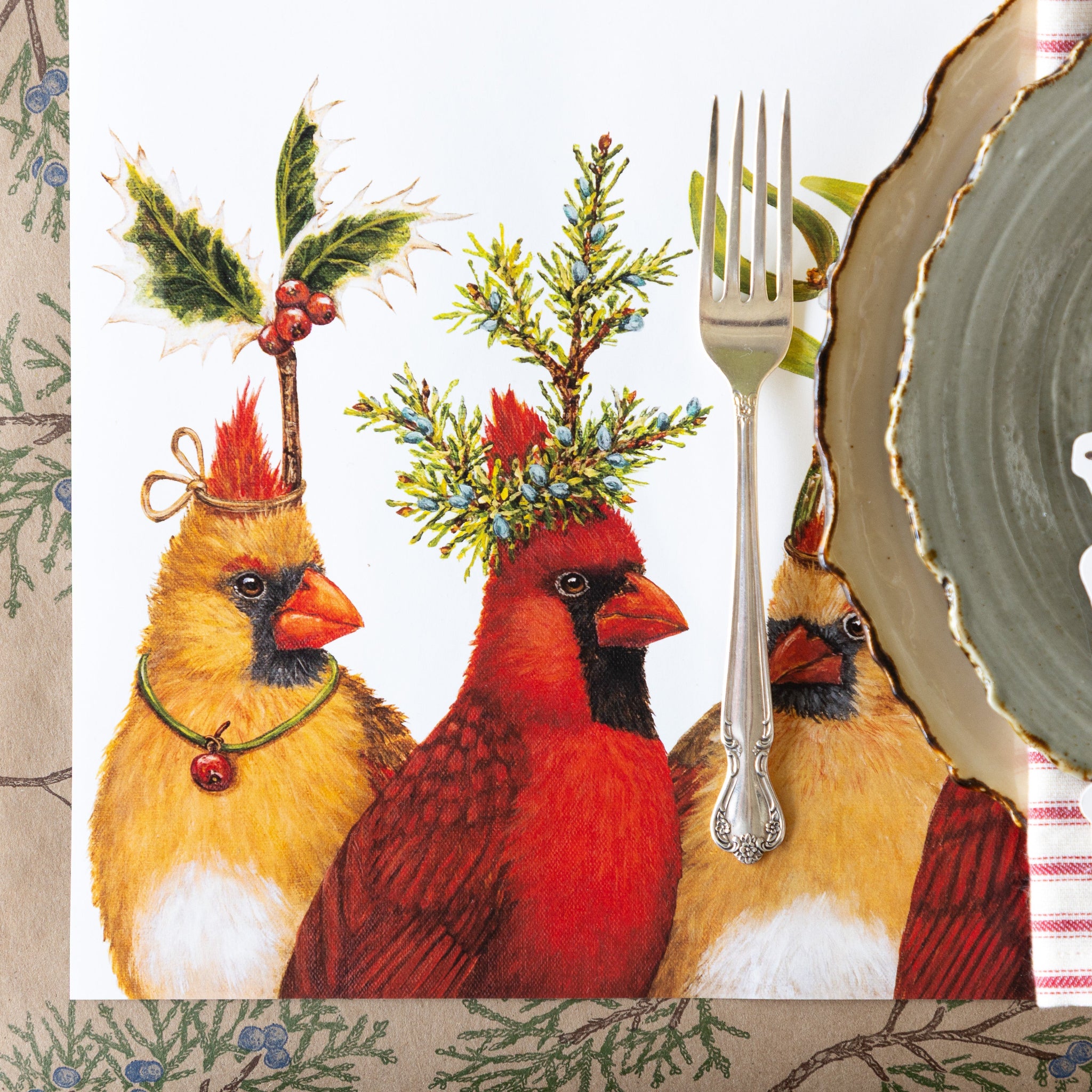 A holiday table setting features the Cardinal Party Placemat on the Juniper Sprigs Runner.