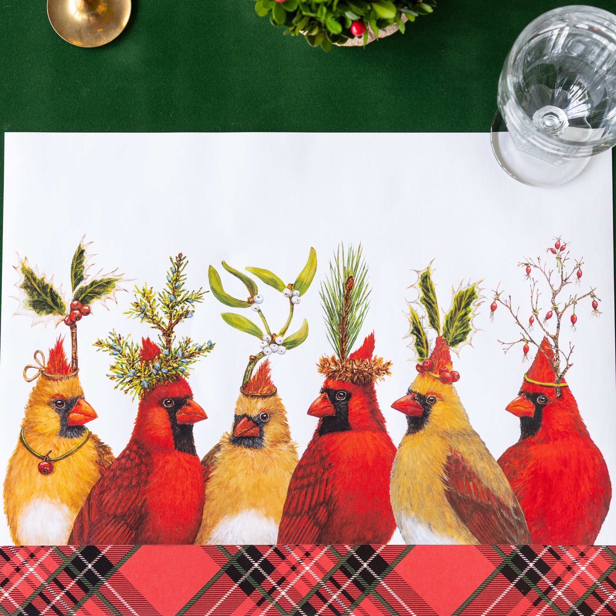 A festive place setting featuring the Cardinal Party Placemat and a glass on the Red Plaid and Green Flocked Runner.