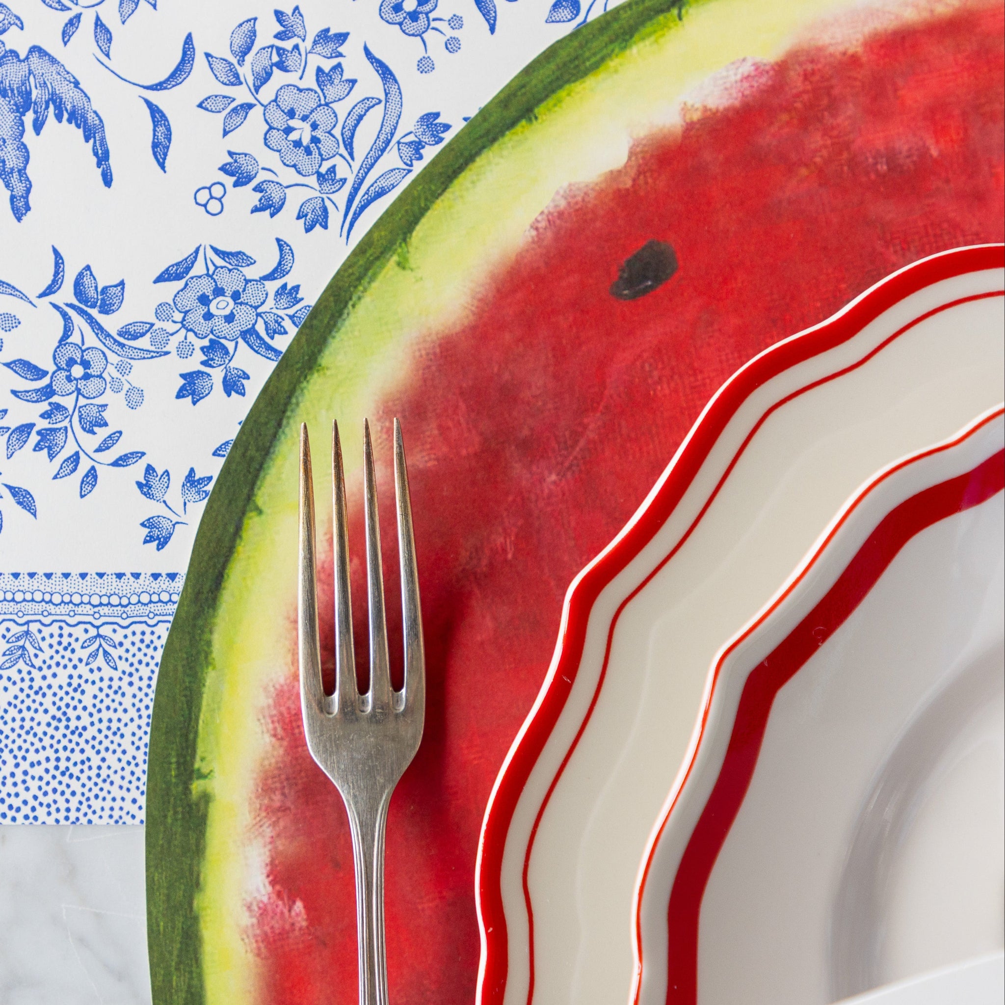 A close up of the Die-cut Watermelon Placemat under a place setting.