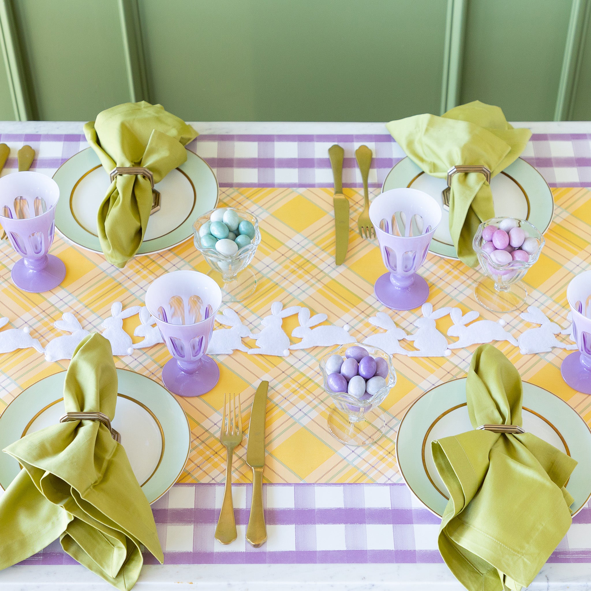 Rabbit Garland Ribbon with white appliqué rabbits made of felt running down a table with a yellow plaid runner and purple glasses on it.