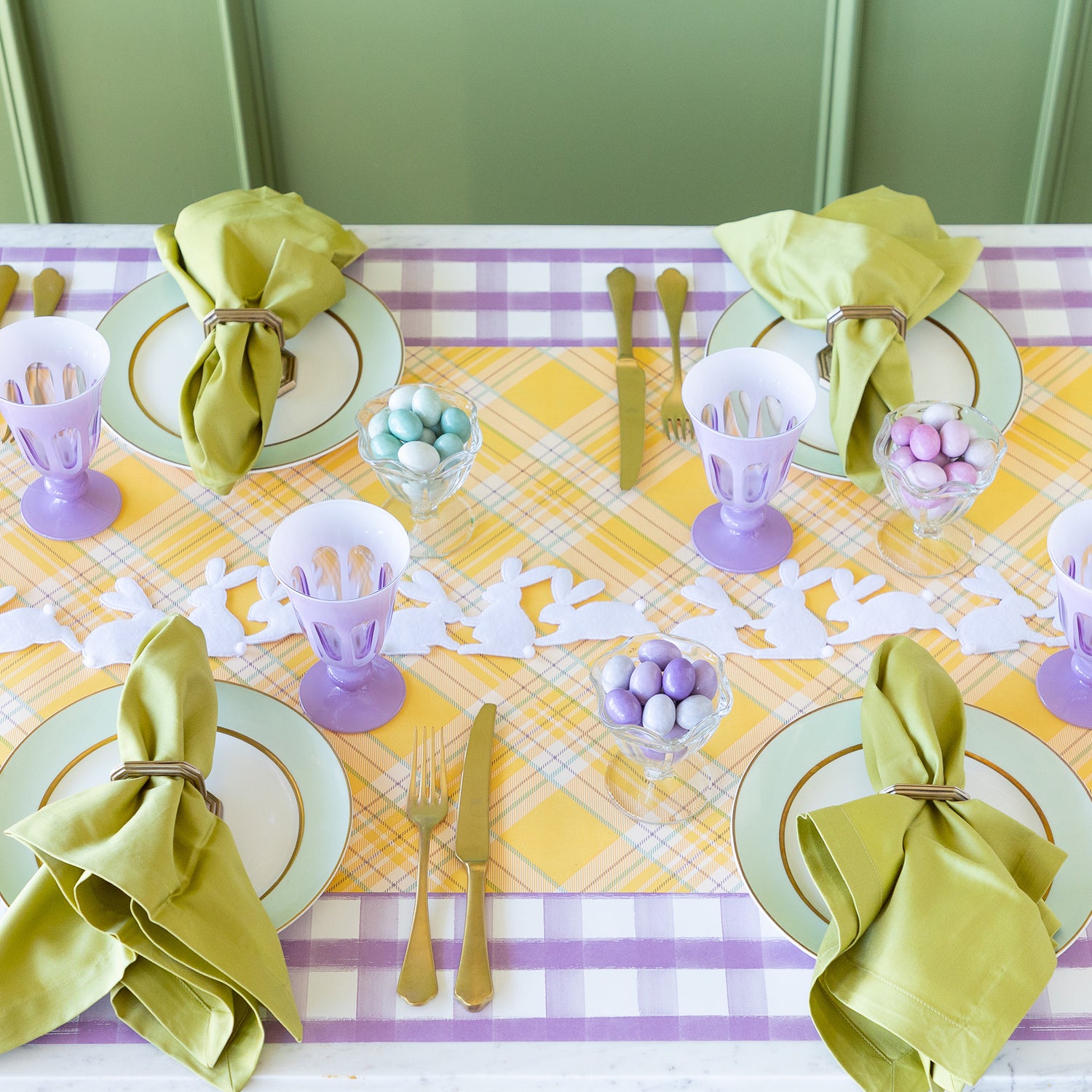 Rabbit Garland Ribbon with white appliqué rabbits made of felt  running down a table with a yellow plaid runner and purple glasses on it. 