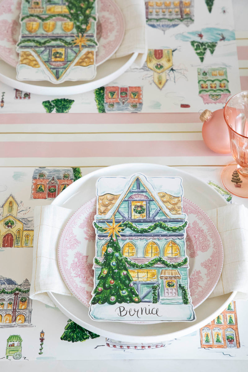 An elegant Christmas place setting featuring a Townhome Table Accent labeled &quot;Bernice&quot; resting on the plate, from above.