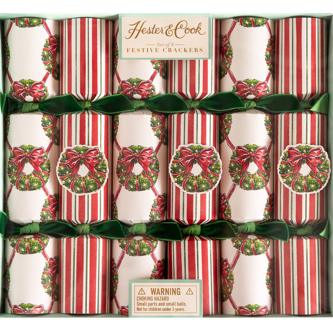 A box of Hester & Cook Holiday Wreath Crackers; some decorated with a wreath lattice pattern and others a red and green stripe pattern––all tied with green velvet ribbons.