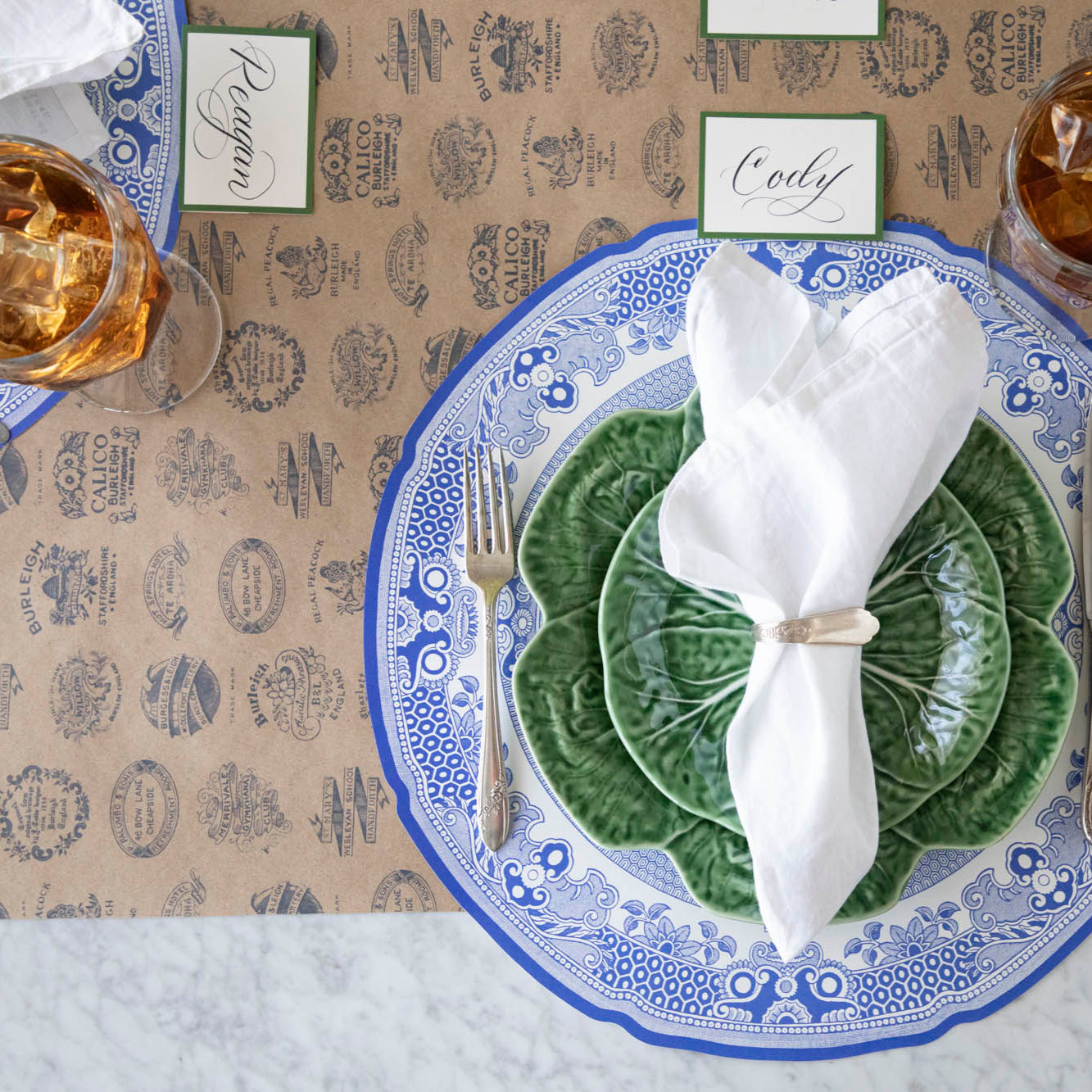 Kraft Burleigh Heritage Runner under the Die-cut Blue Willow Plate Placemat with an elegant place setting on top.