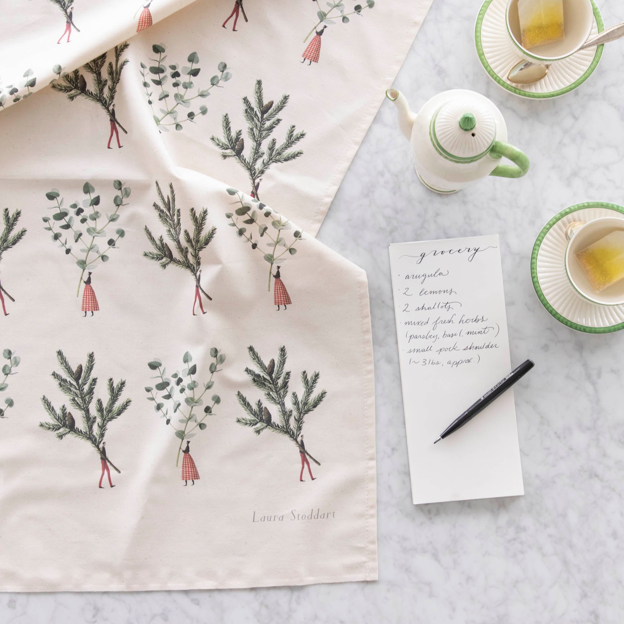 Laura Stoddart Spruce & Eucalyptus Multi Tea Towel next to a grocery list and tea cups.