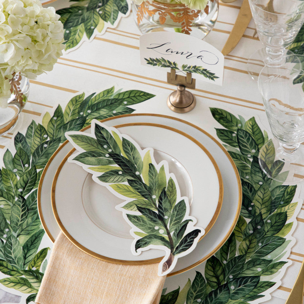 The Die-cut Green Laurel Wreath Placemat under an elegant table setting.