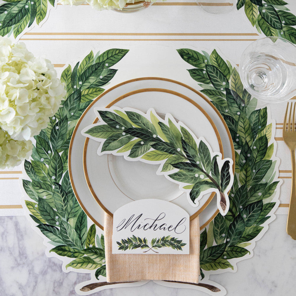 The Die-cut Green Laurel Wreath Placemat under an elegant table setting, from above.