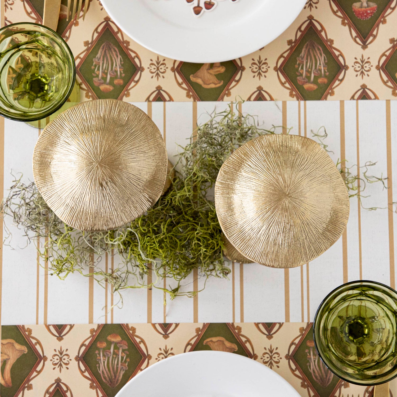 A gold metal mushroom figurine placed on a table with a harvest tablescape in the background.