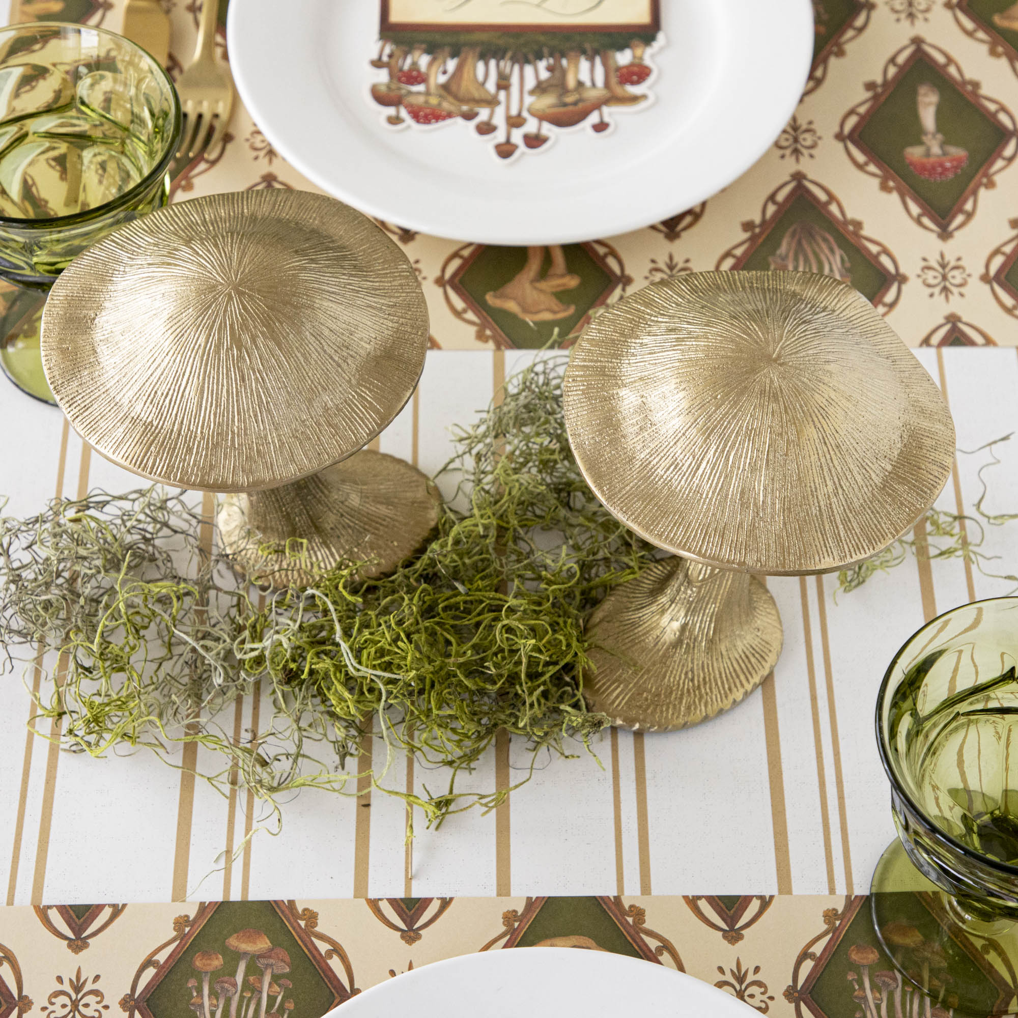 A gold metal mushroom figurine placed on a table with a harvest tablescape in the background.