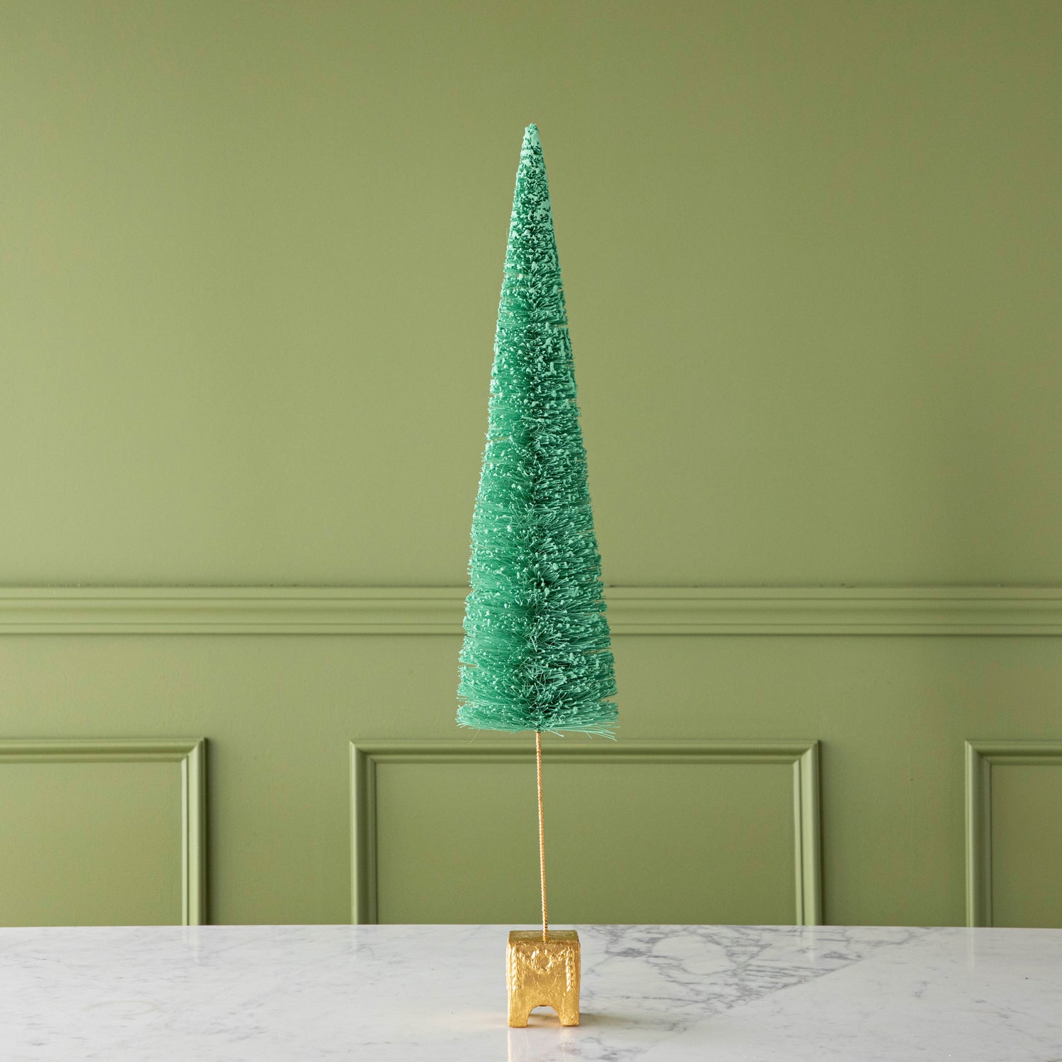A 29" Green French Forest Sisal Tree with a gold base, on a marble table.