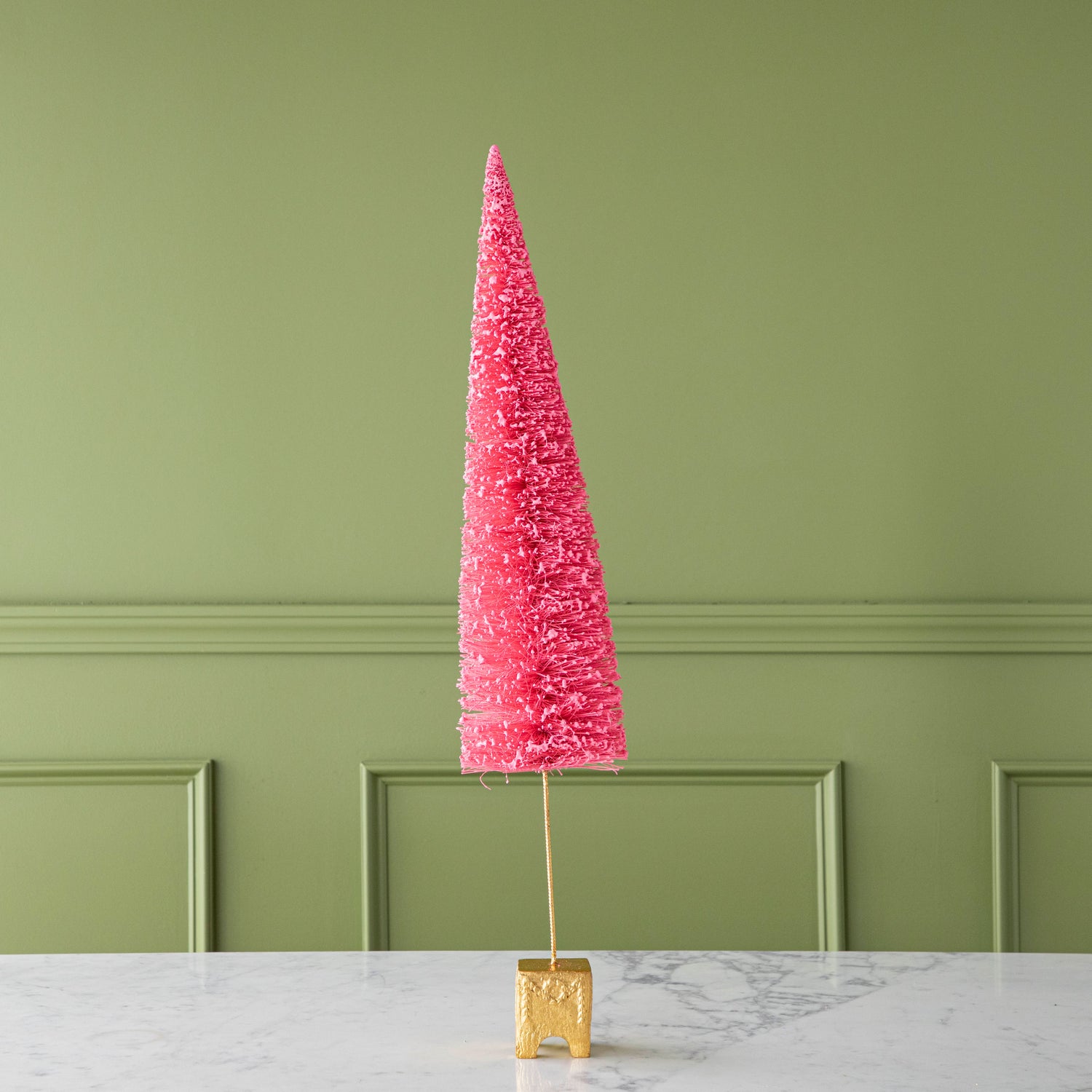 A 29" Coral French Forest Sisal Tree with a gold base, on a marble table.