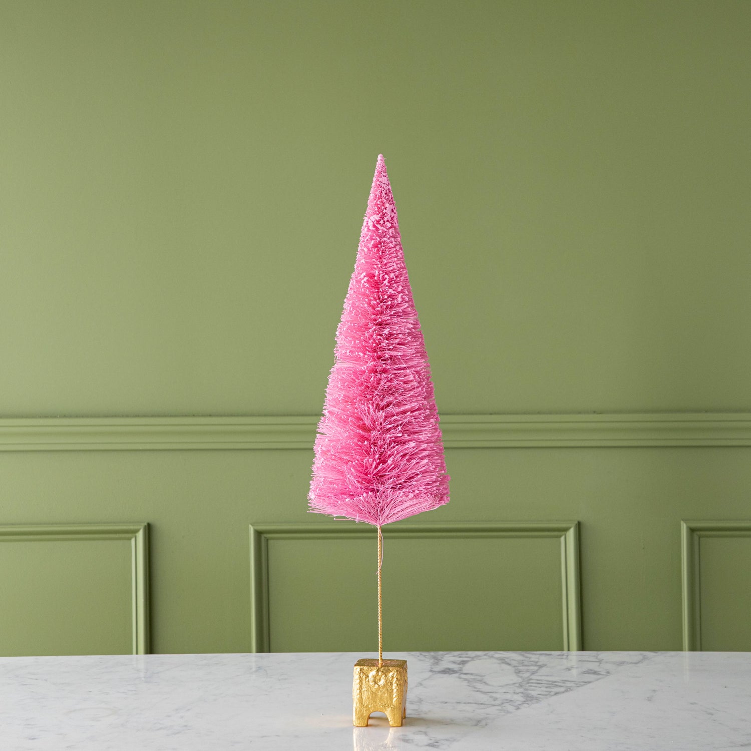 A 26" Light Pink French Forest Sisal Tree with a gold base, on a marble table.