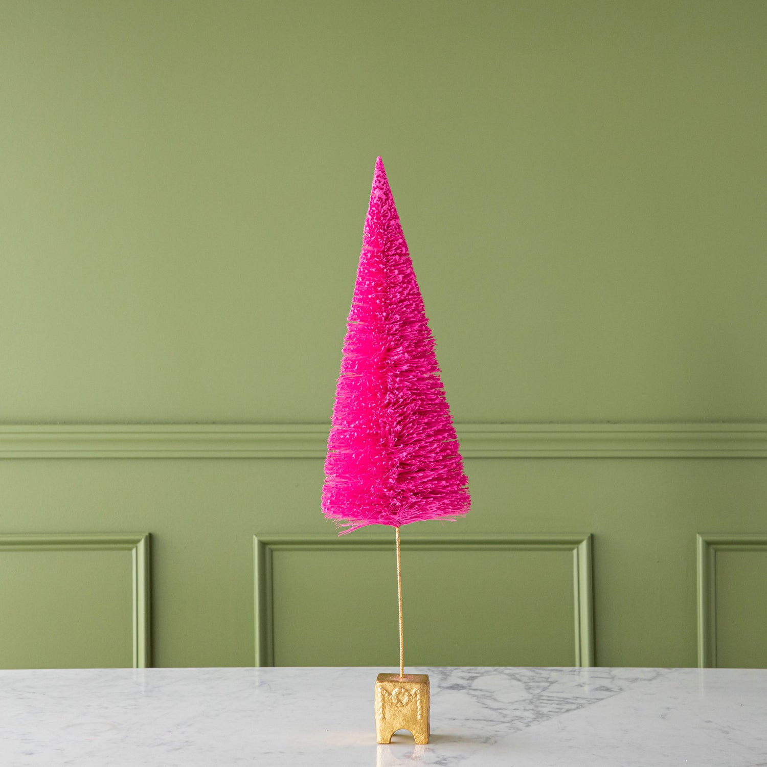 A 26" Hot Pink French Forest Sisal Tree with a gold base, on a marble table.