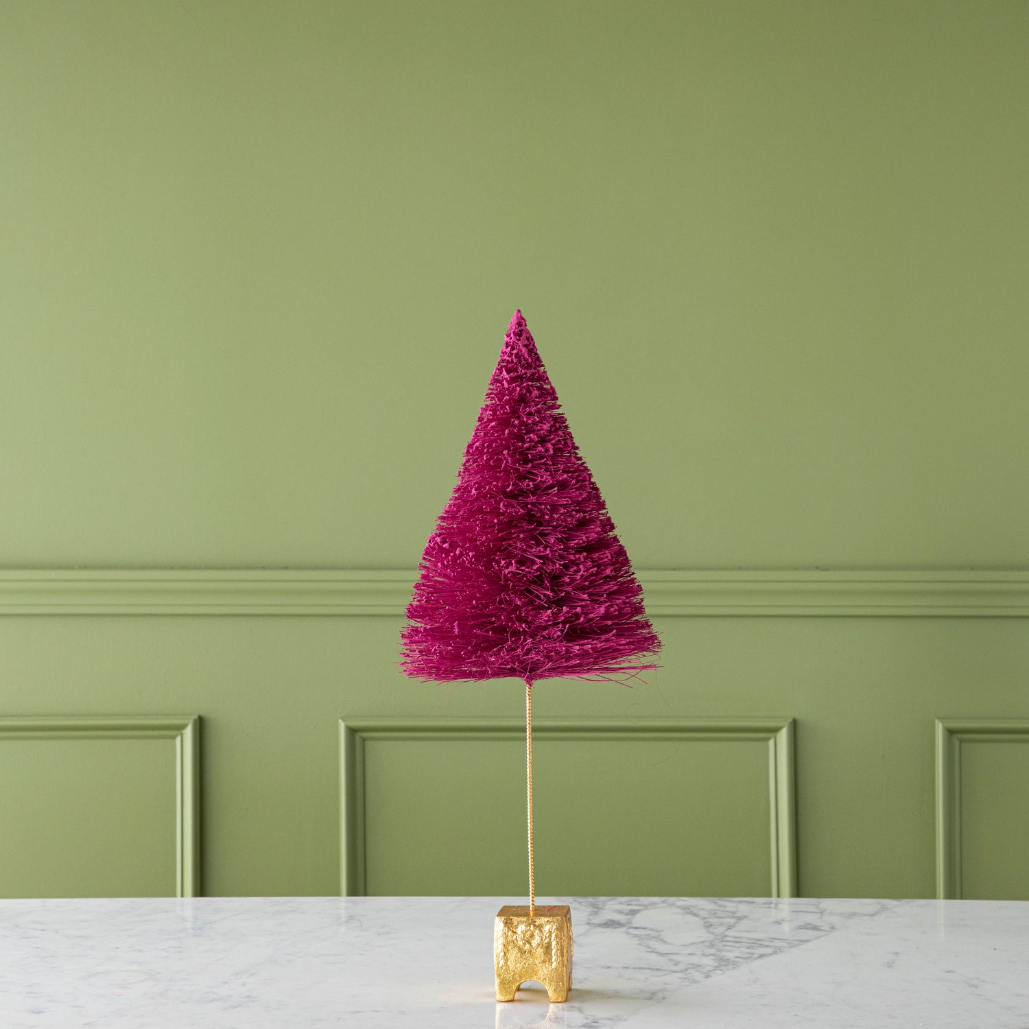A 22" Magenta French Forest Sisal Tree with a gold base, on a marble table.
