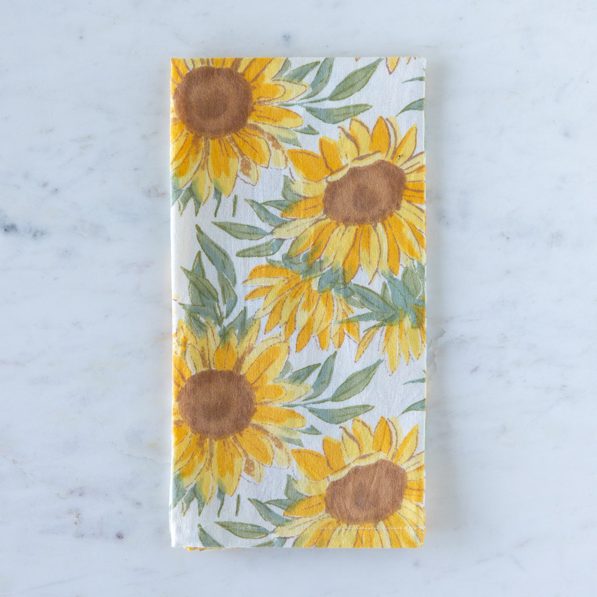 Sunflower pattern cloth napkin on a marble table.