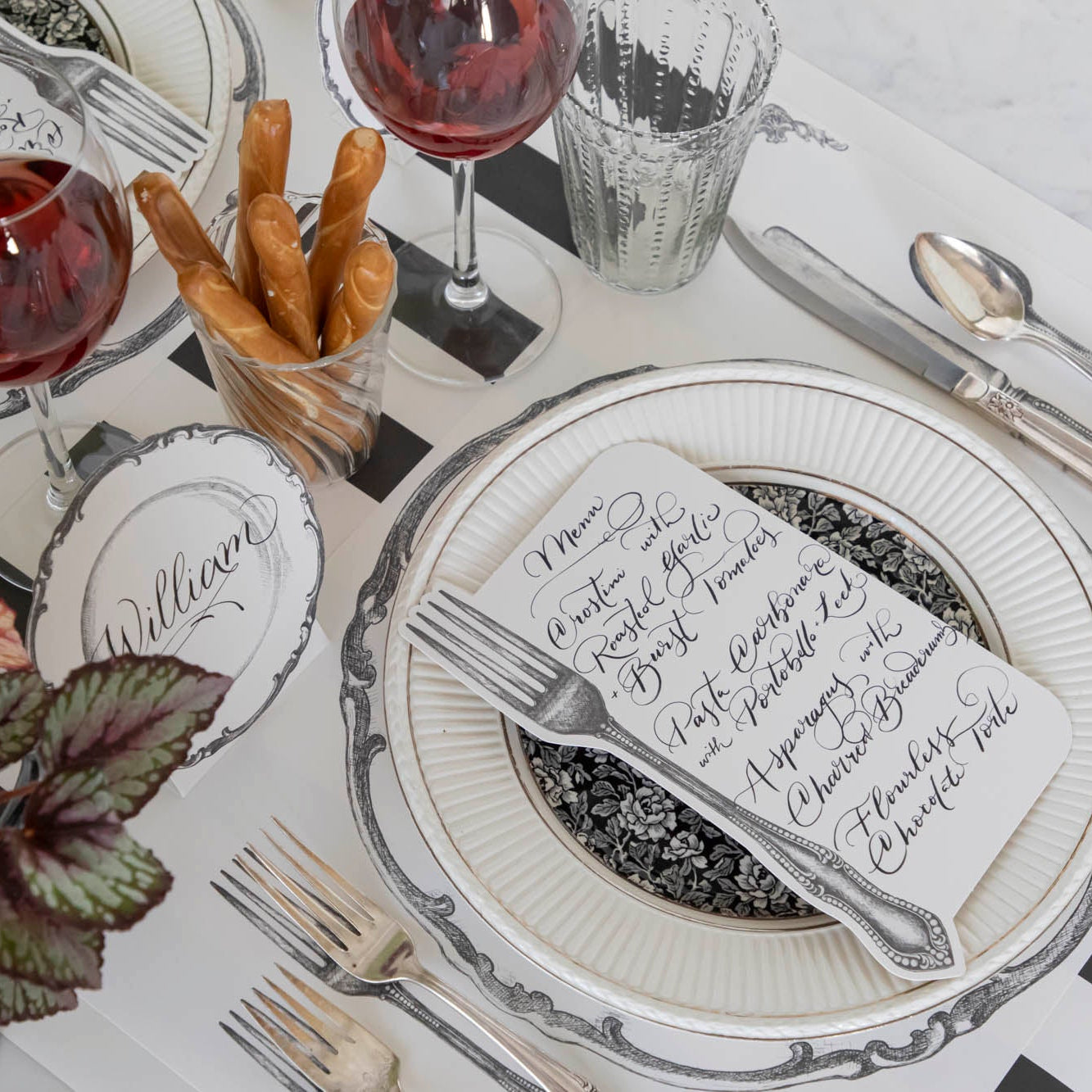 Vintage Fork Table Card with a menu written on it, resting on dinner plates on a table setting for one.