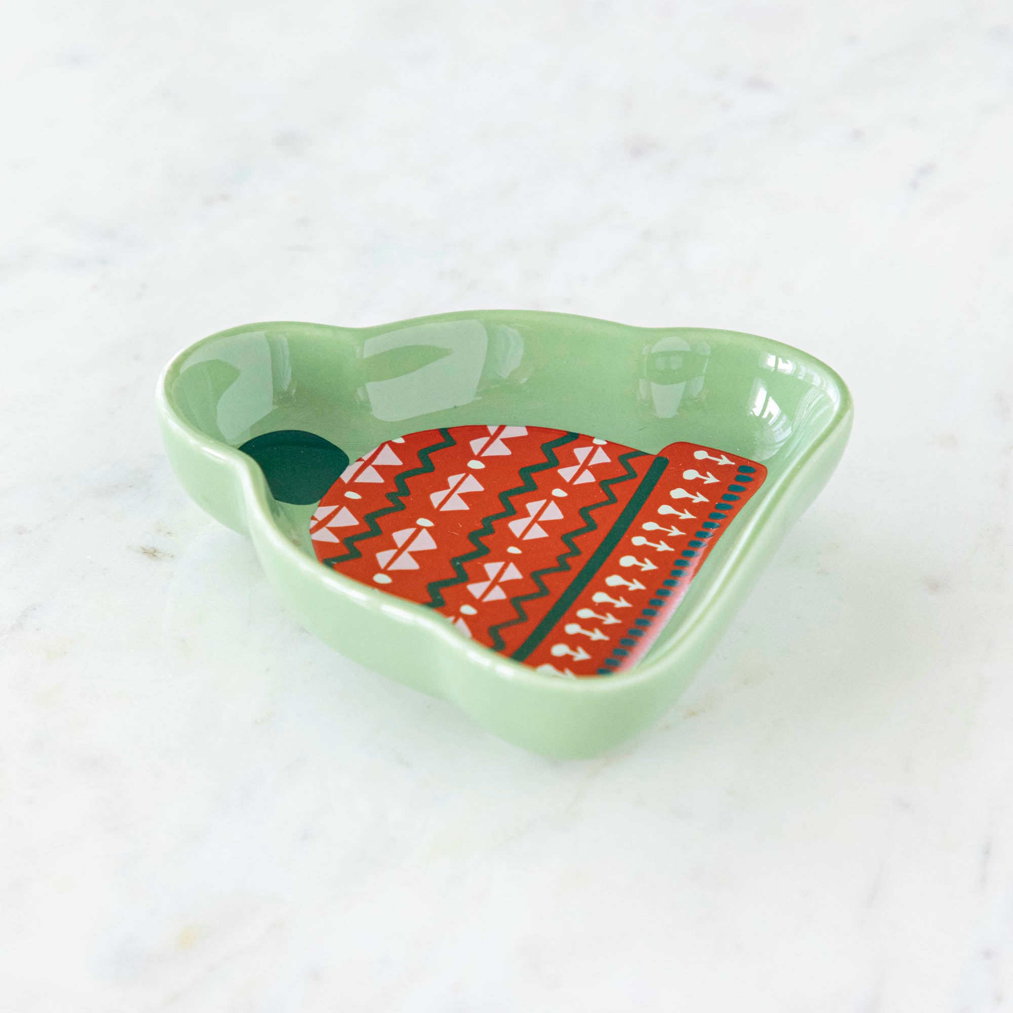 A stoneware pinch bowl with a beanie shape featuring a Christmas-themed pattern.