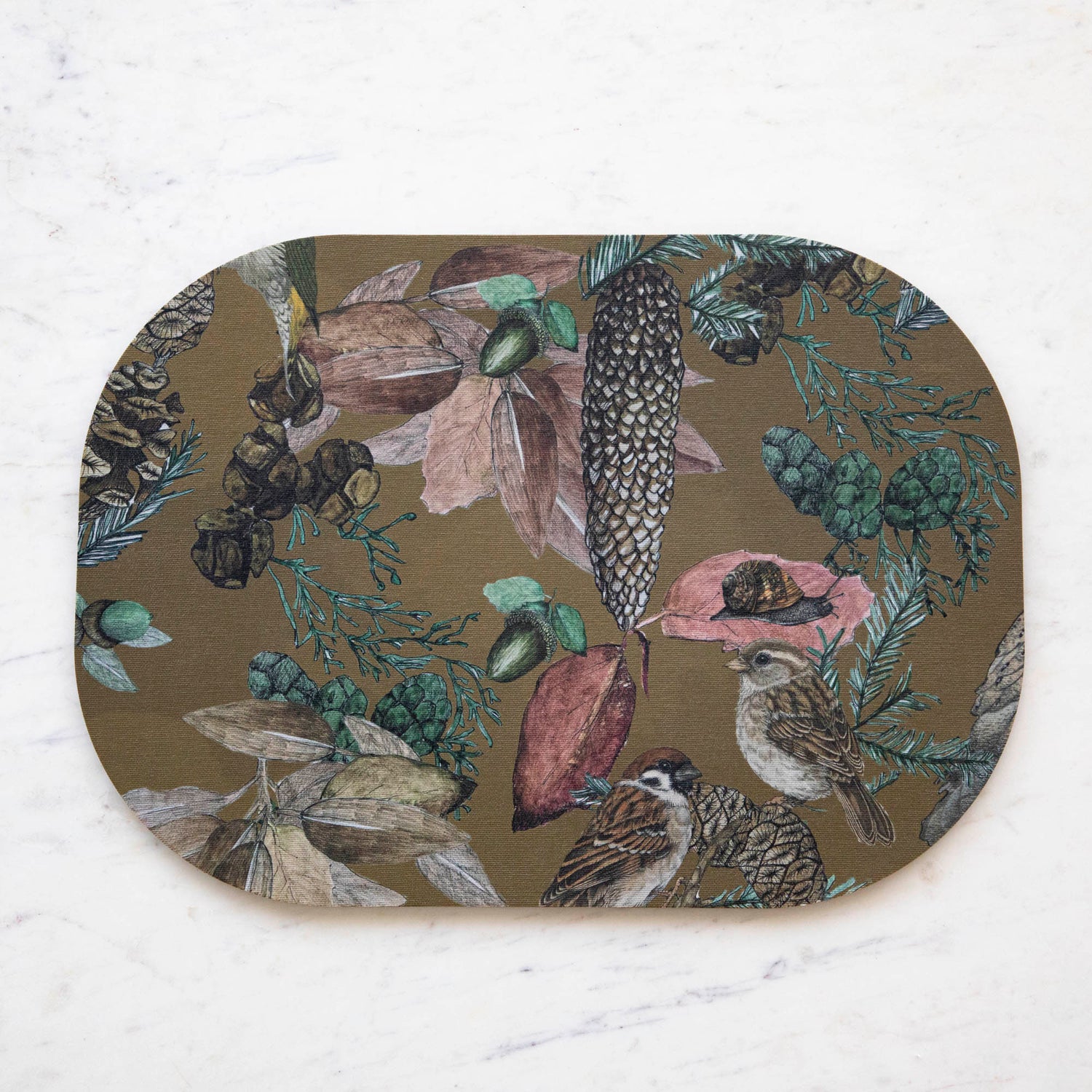 Oval placemats with a bird, floral, and butterfly pattern, displayed on a table with striped tablecloth.