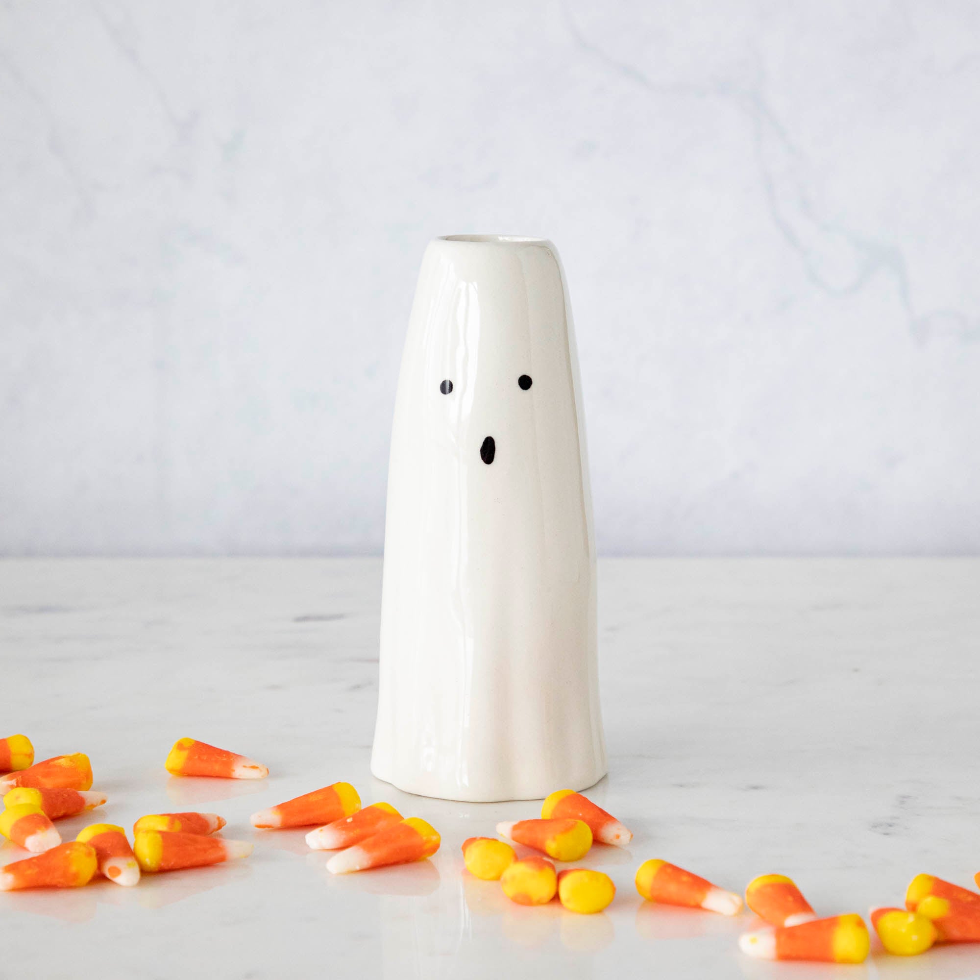 A Phantom Candleholder on a table surrounded by candy corn.