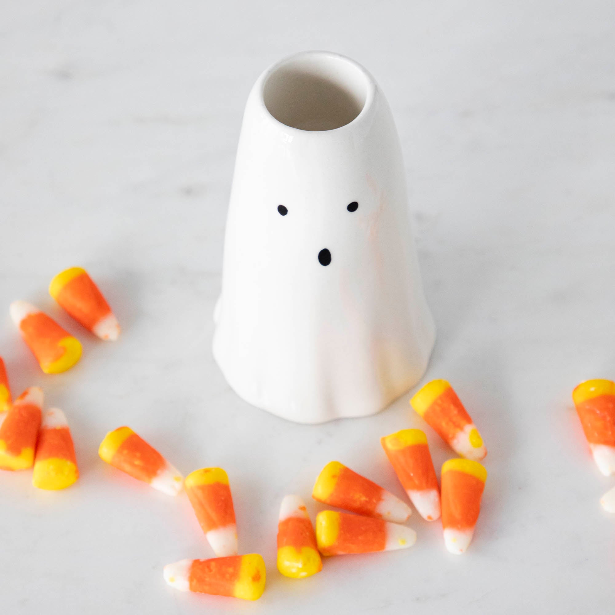 A Phantom Candleholder on a table surrounded by candy corn.